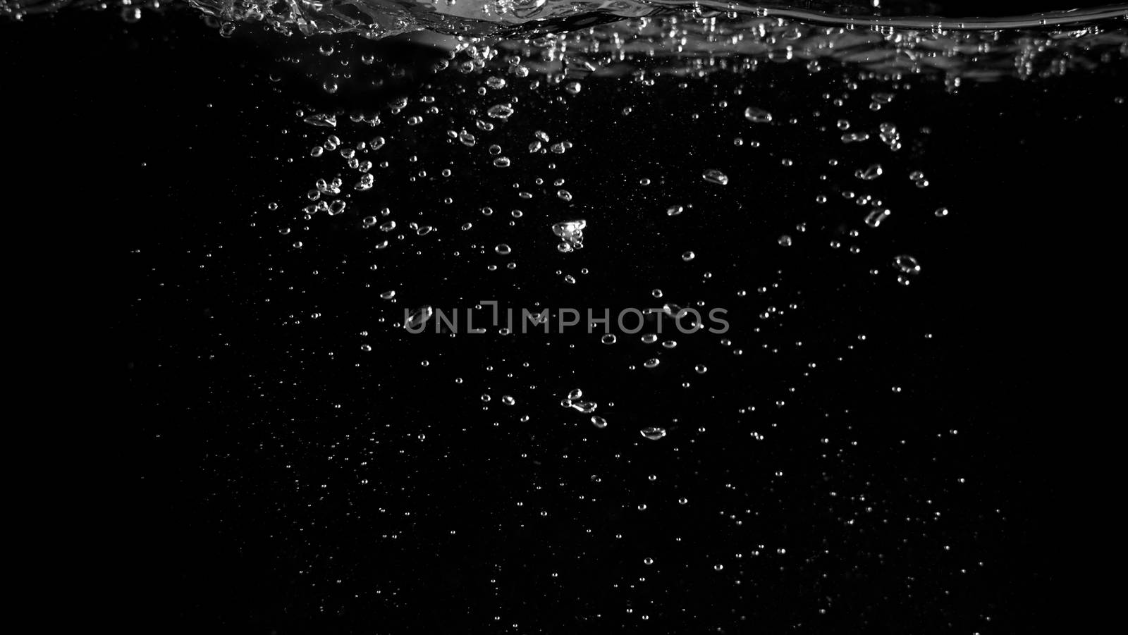 Water bubbles floating on black background which represent refreshing of refreshment from soda or carbonated drink and power of liquid that splashing or fizzing with blowing and streaming by air pump.