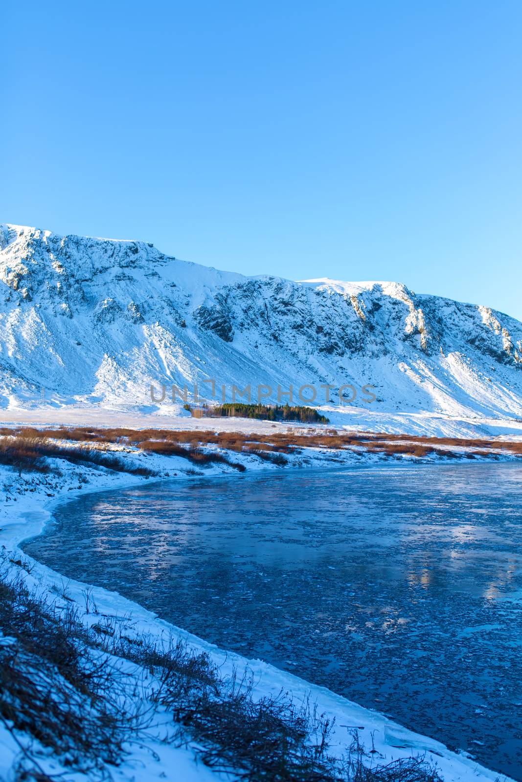 Iceland's breathtaking winter landscapes. River with pieces of ice on the background of mountains.