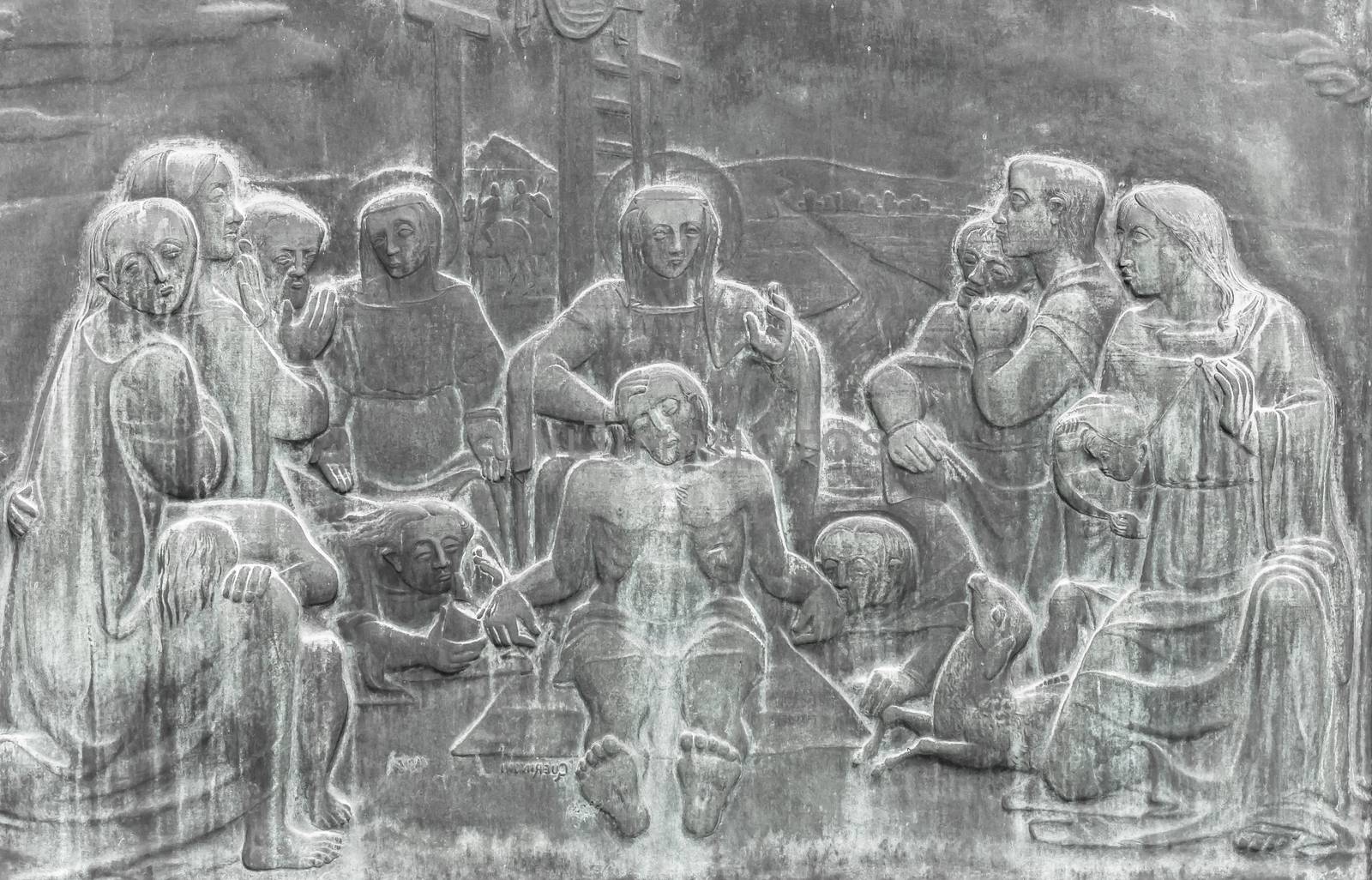 Stone wall engraving scene depicting the Lamentation of Christ