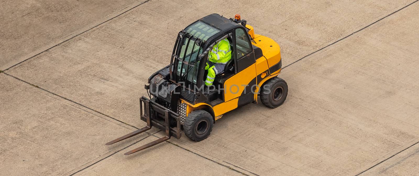 Worker in a yellow fork lift by DamantisZ