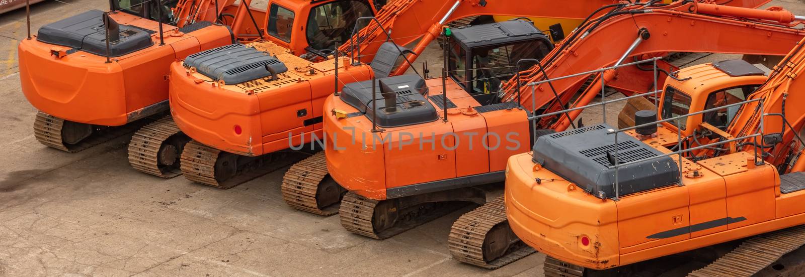 Old orange heavy excavators parked in one row by DamantisZ