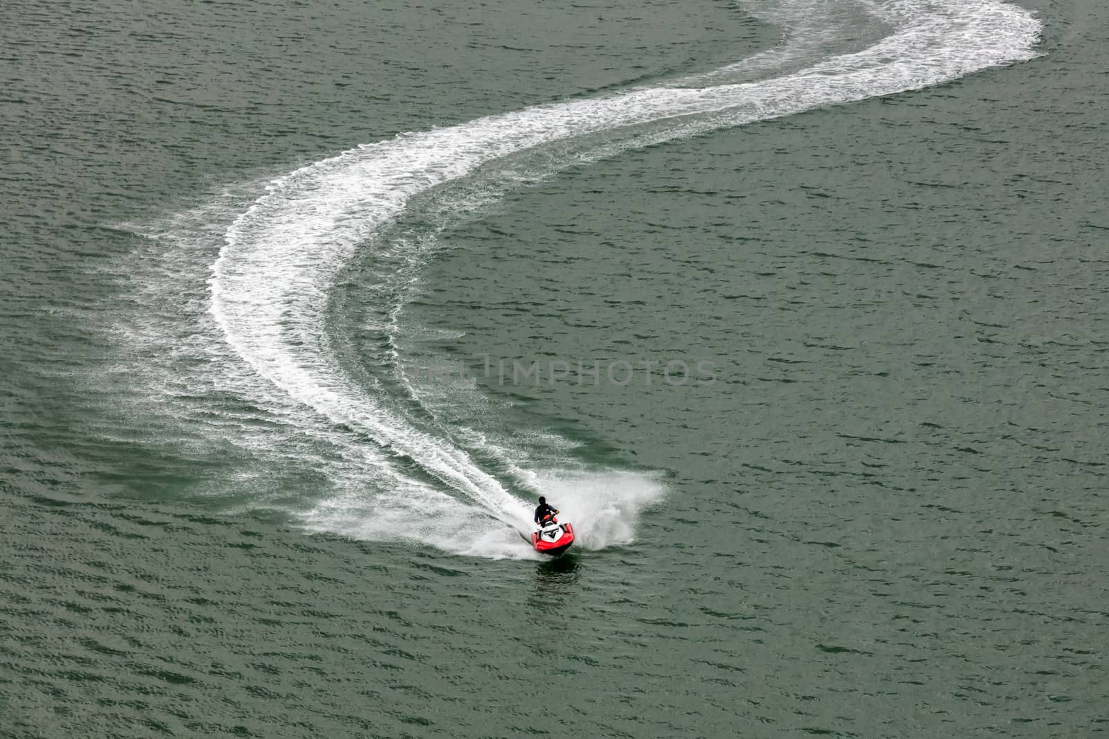 Red jetski moving very fast leaving white trace behind it. by DamantisZ