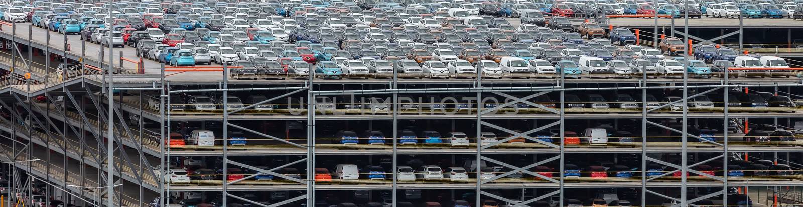 Southampton port, England, UK - June 08, 2020: Multilevel parking lot, storage facility in the port of Southampton. Full of various imported cars. Aerial view.