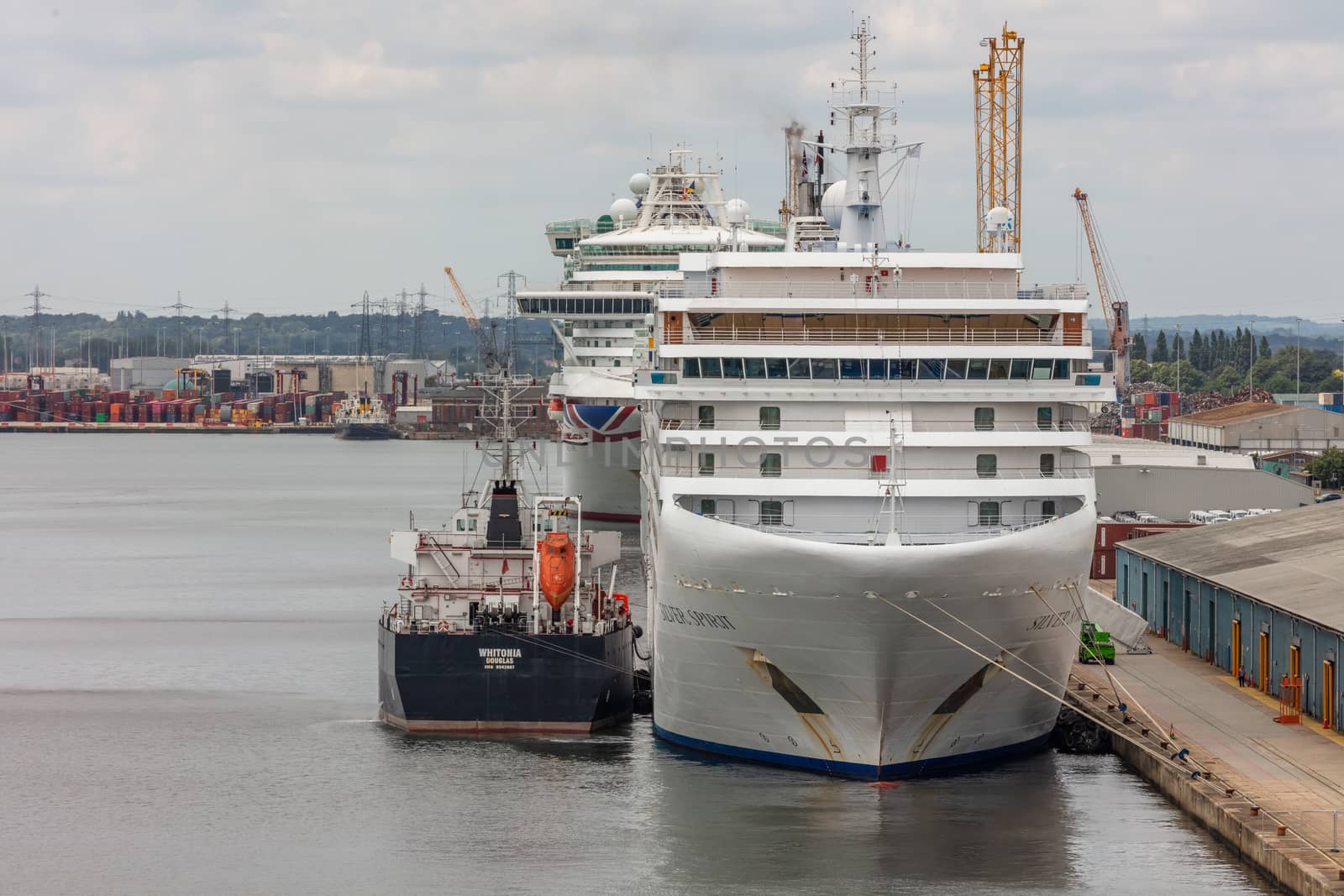 Southampton port, England, UK - June 08, 2020: Silver Spirit cruise ship docked in Southampton port and being refueled by fueling ship Whitonia. Some other cruise ship in the background.