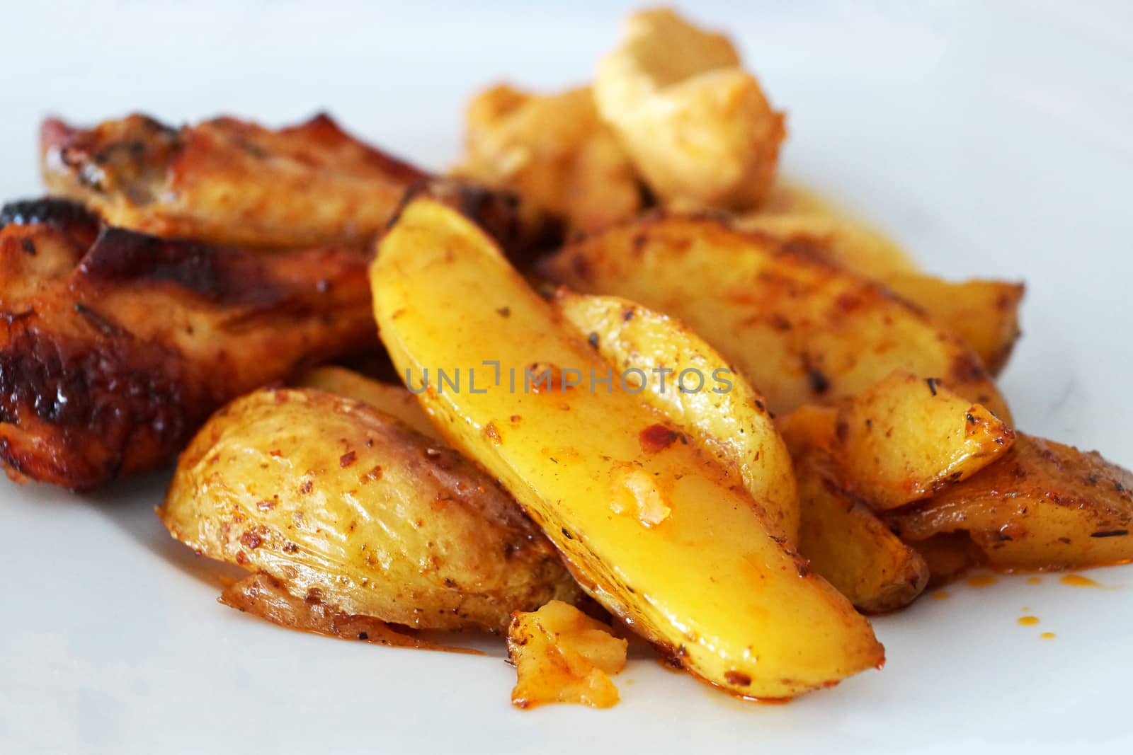 baked potatoes with meat on a white dish close up by Annado