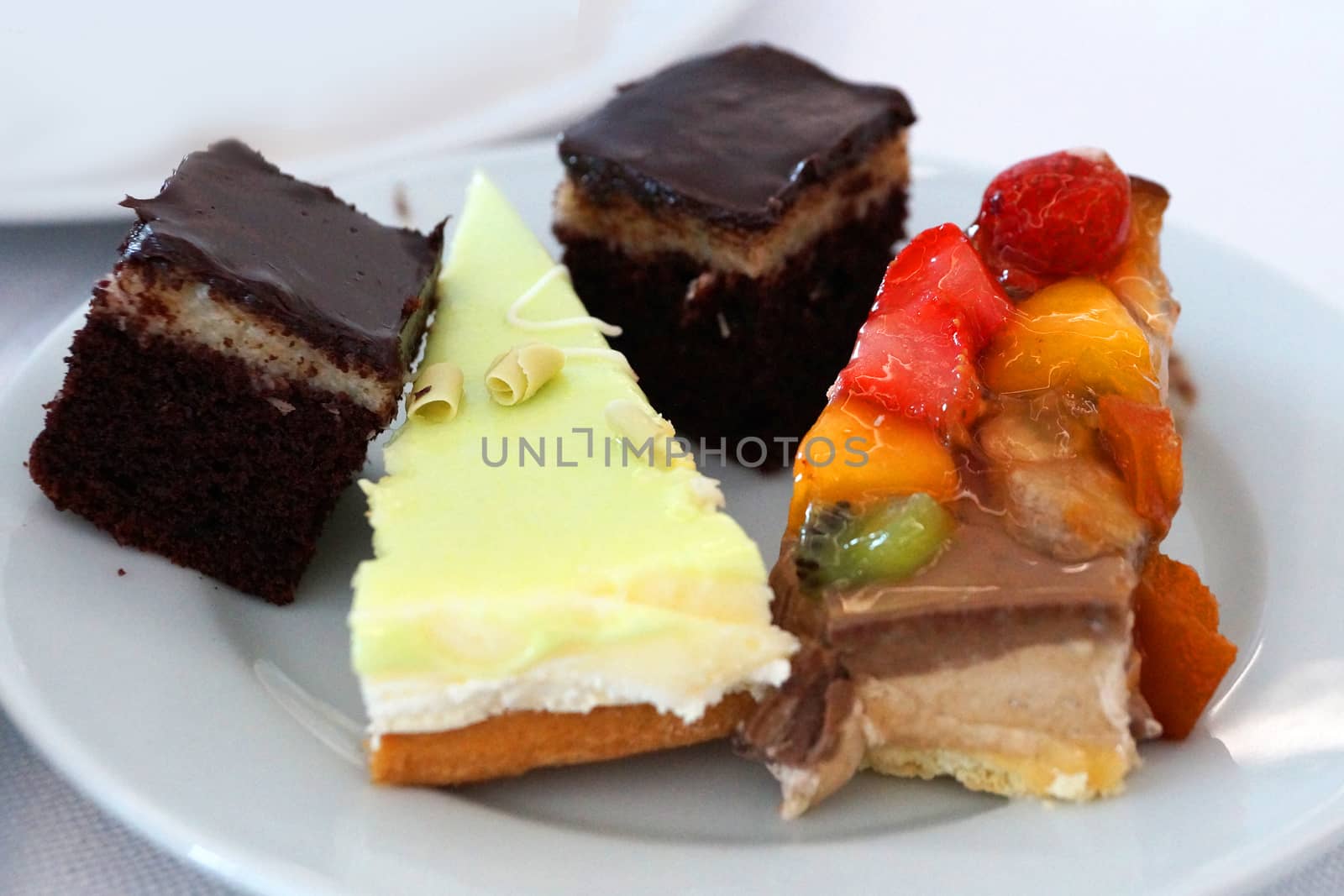 pieces of different cakes on a white dish, sweet dessert