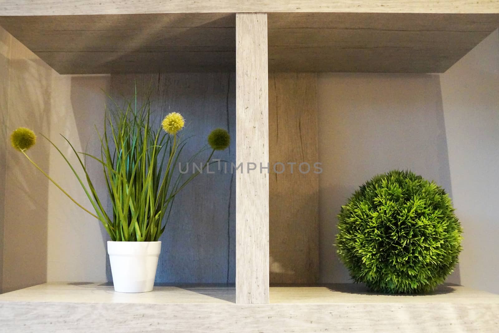 white interior shelf with decorative balls and potted plants.