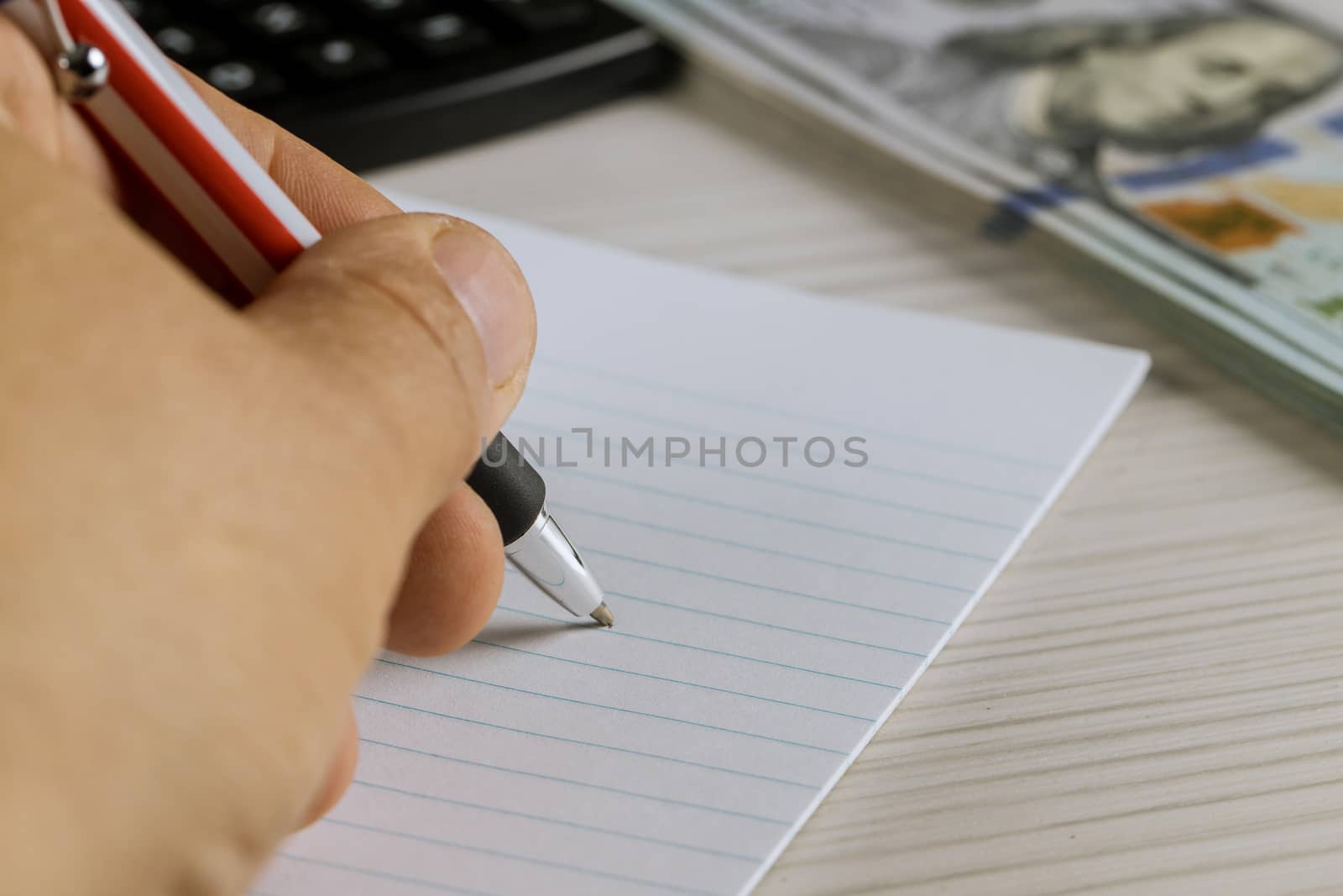 Notebook with blank pages a pen on workspace office table supplies and us dollars