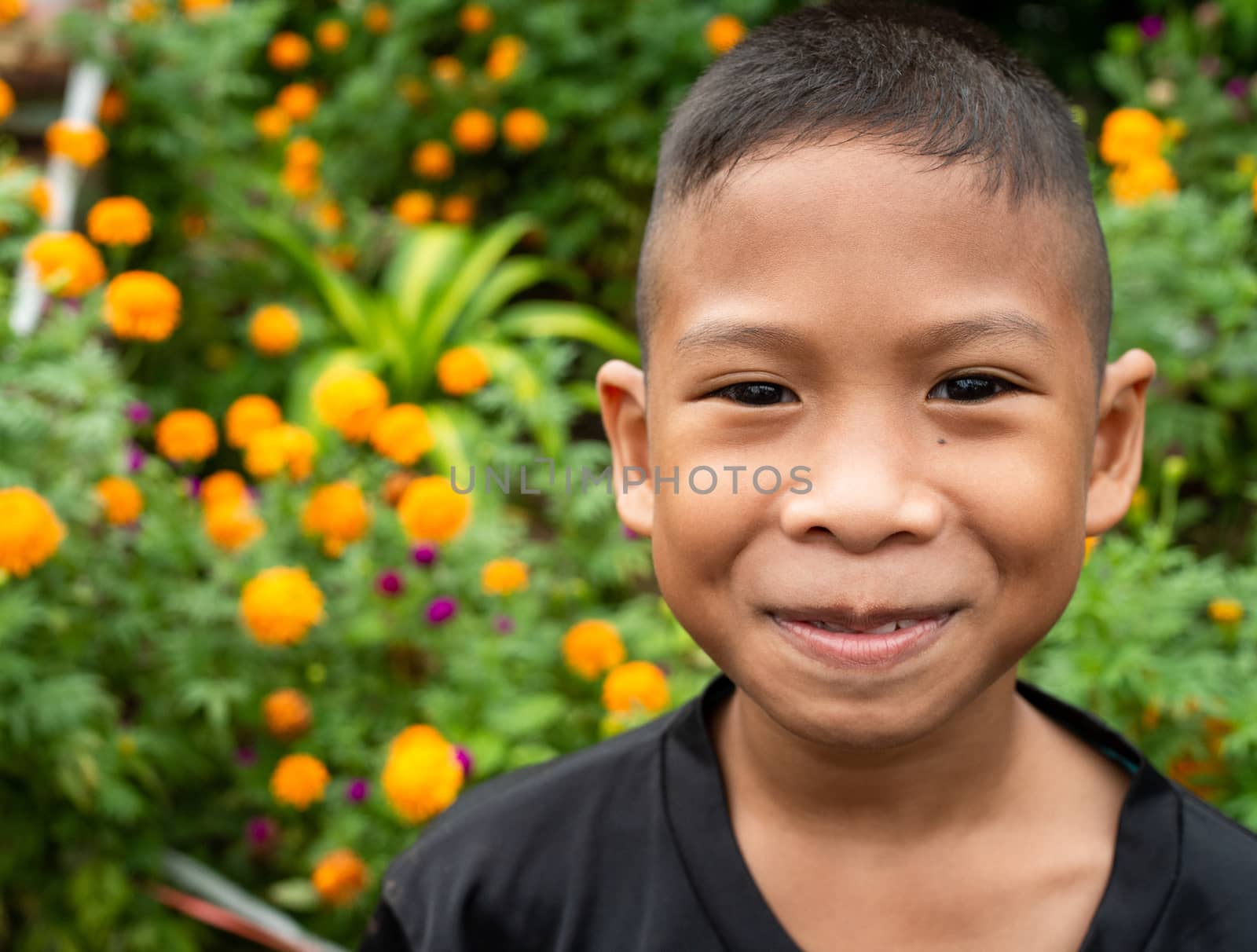 Boy smiling face portrait On a garden background.