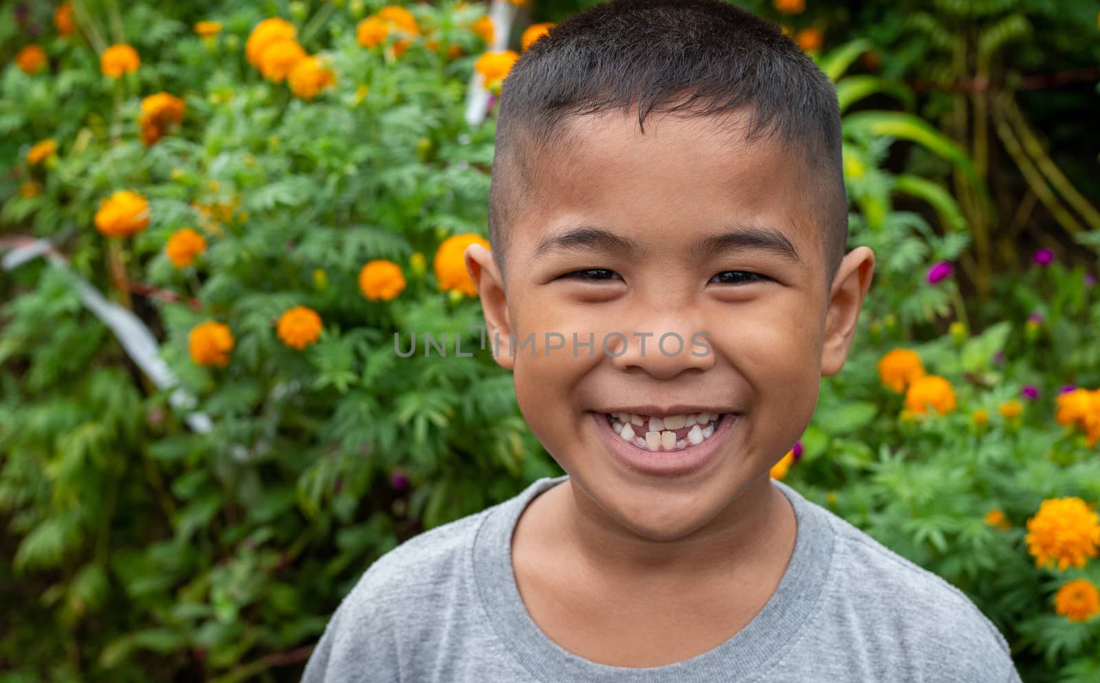 Boy smiling face portrait On a garden background. by Unimages2527