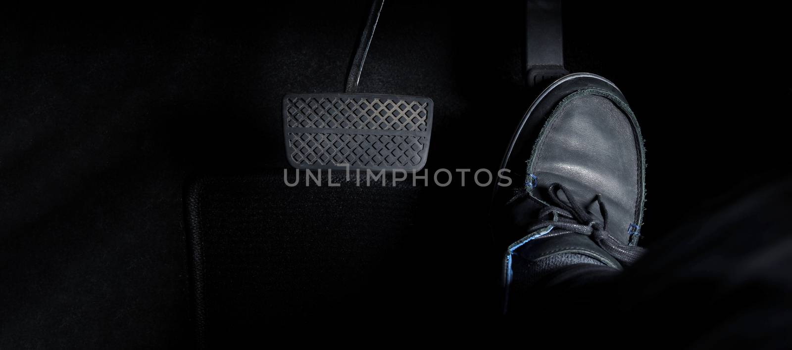 Man foot and accelerator and brake pedal inside the car or vehic by gnepphoto