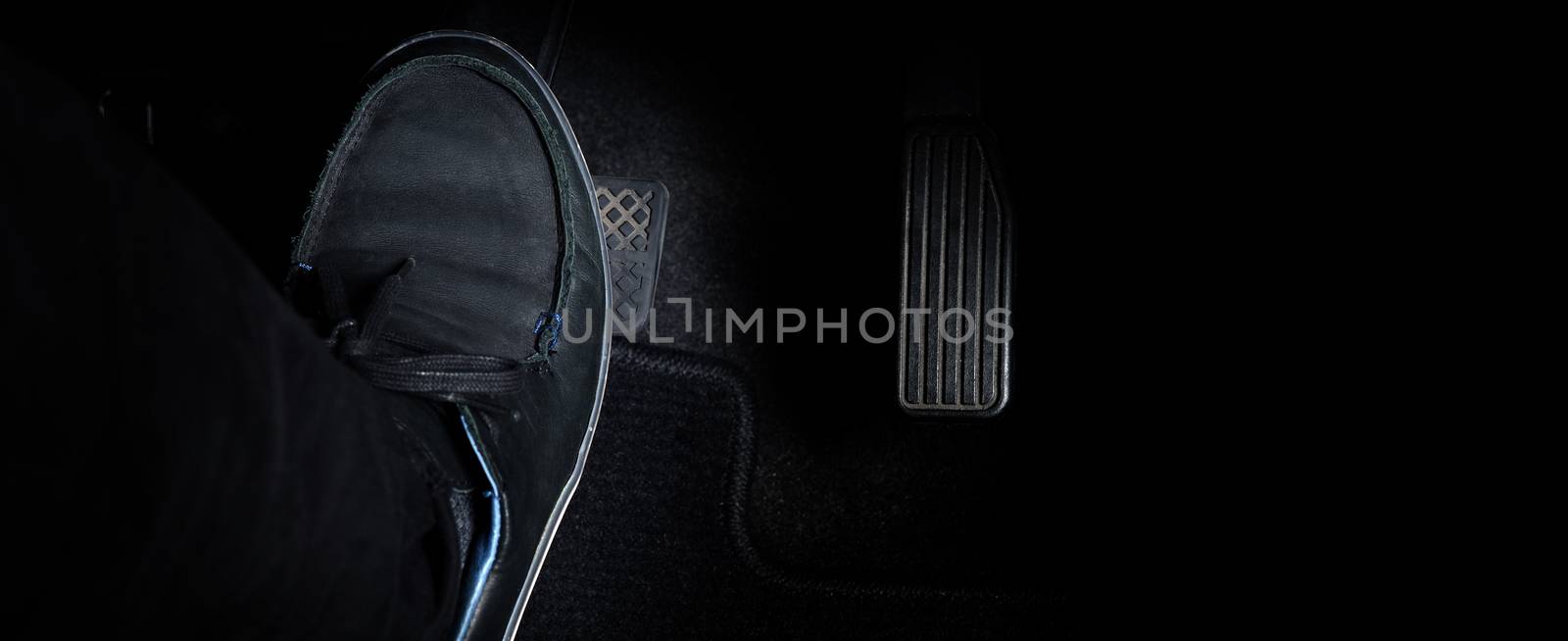 Man foot and accelerator and brake pedal inside the car or vehic by gnepphoto