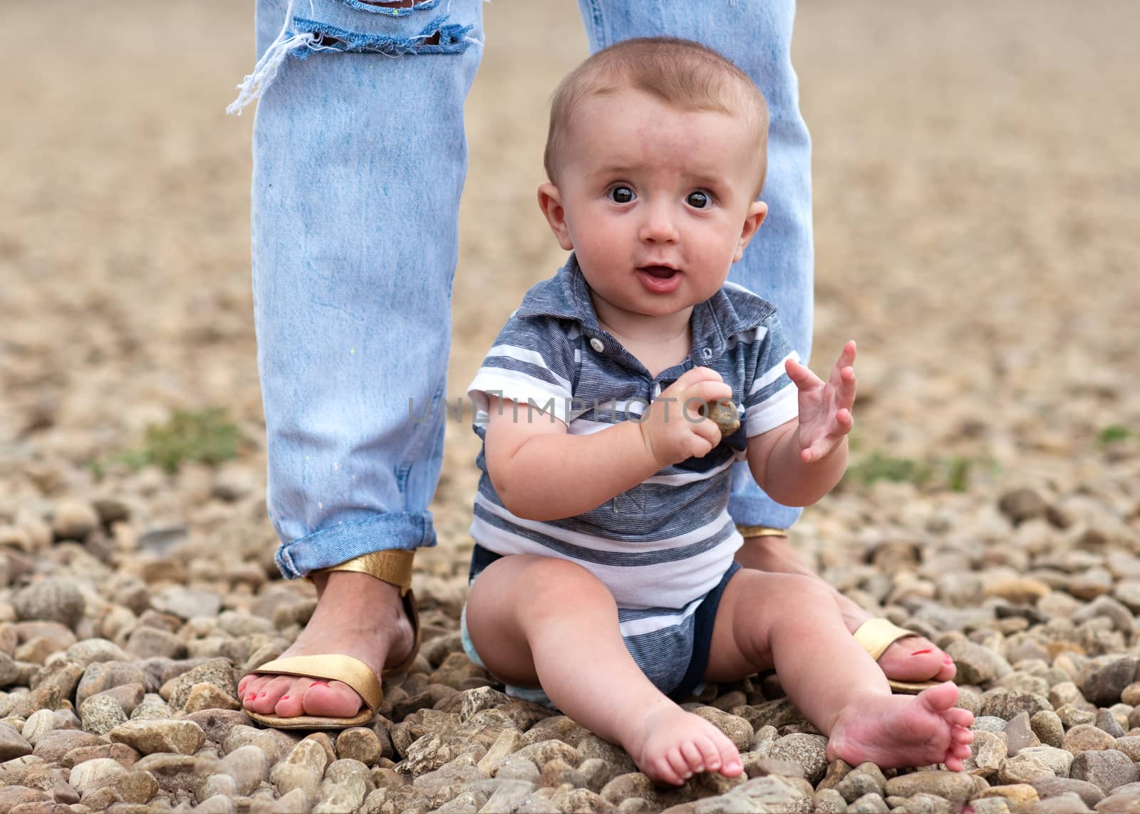 Small boy playing with stones on the seaside