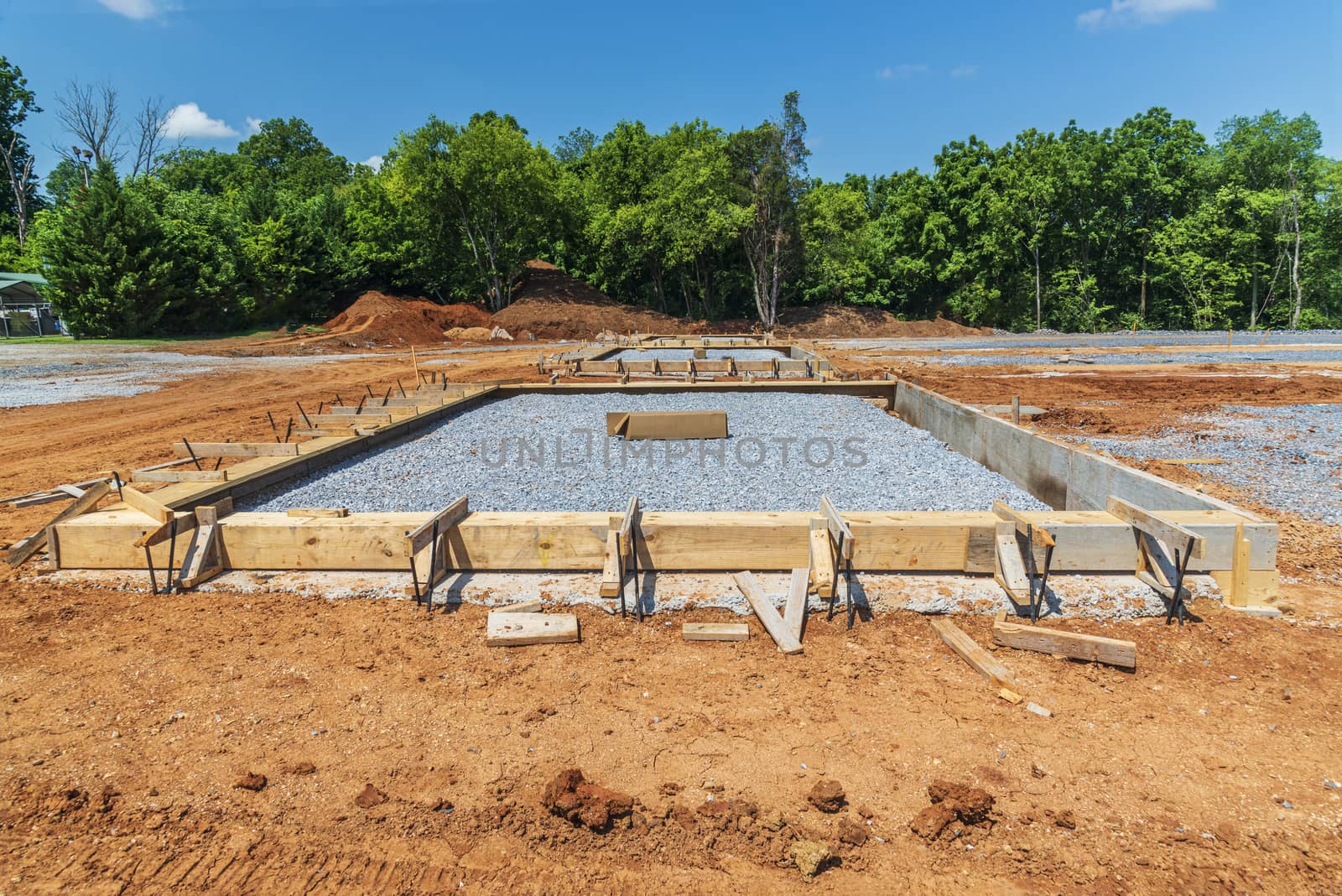 Horizontal shot of a wooden frame and crushed rock ready for a concrete slab to be poured.