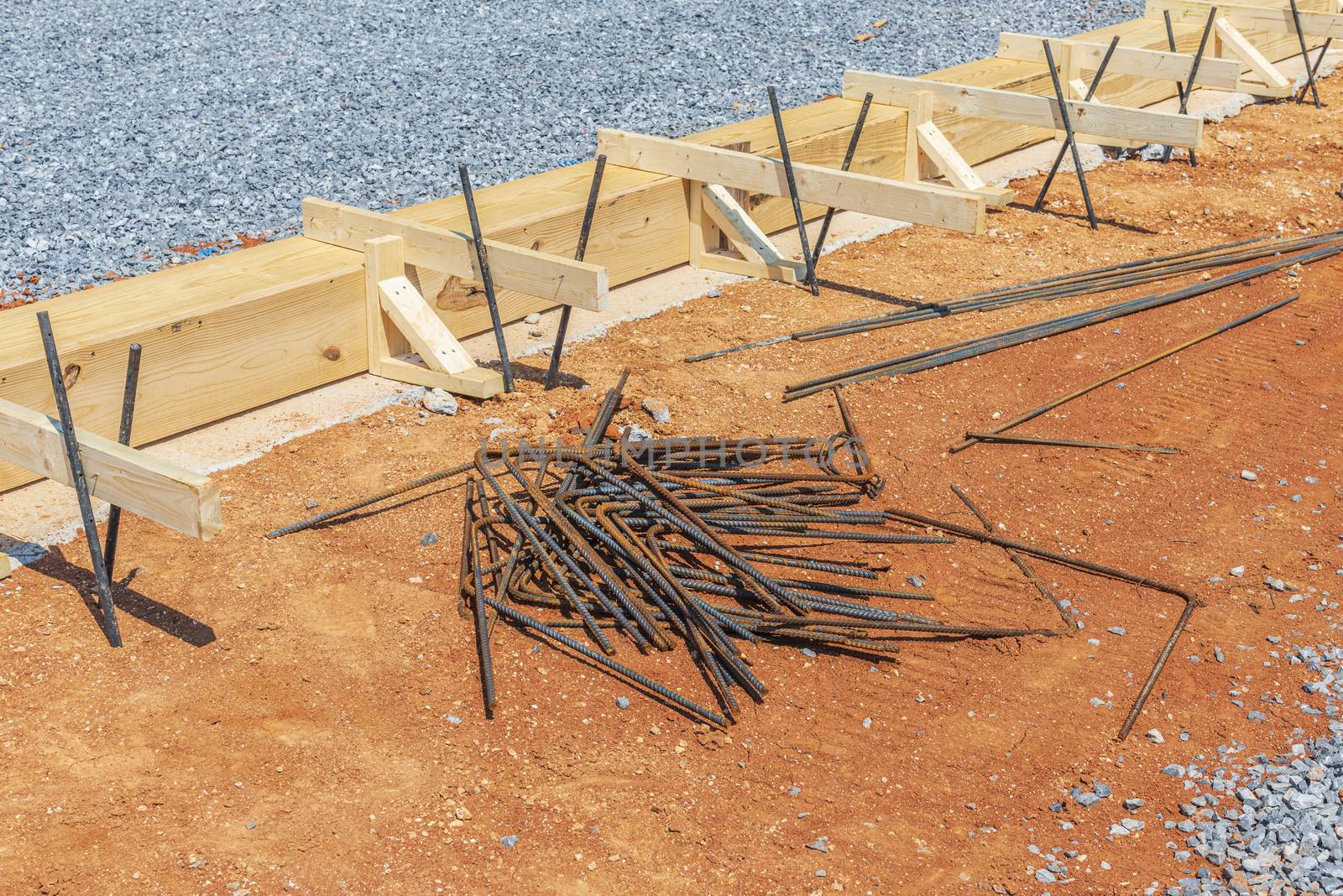 Horizontal shot of wooden framing and iron rods in preparation for concrete to be poured for the foundation.