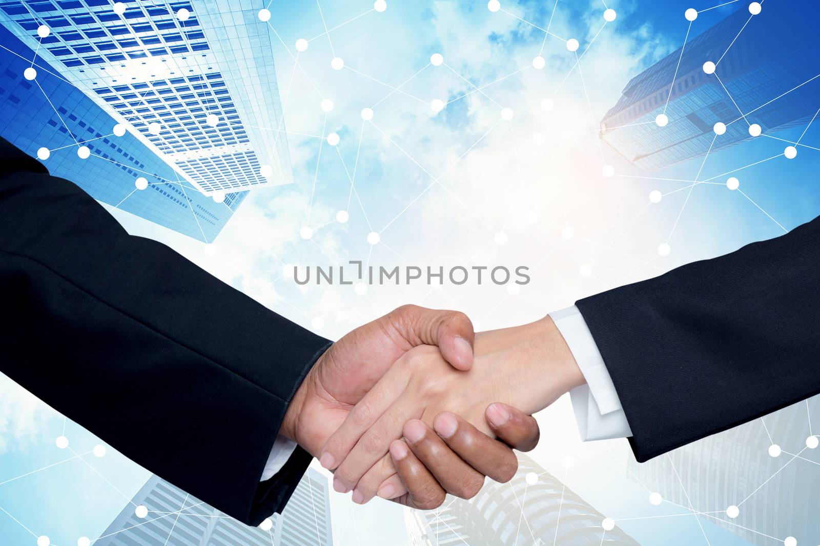 Handshake between a businessman and a businesswoman with building city background, partnership with business people success.