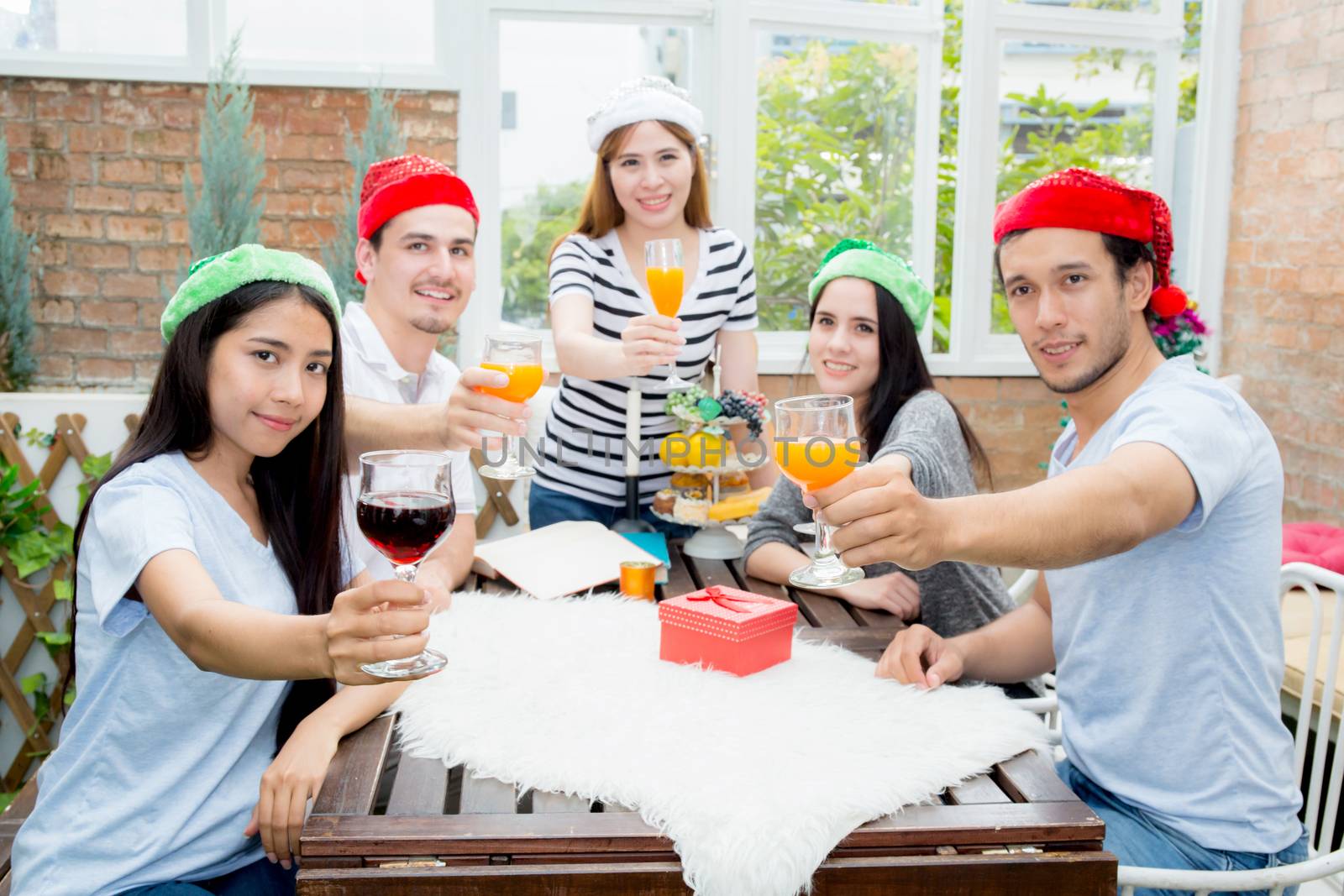 Asian group people drinking at party outdoor. Group of friends cocktails in hand with glasses.