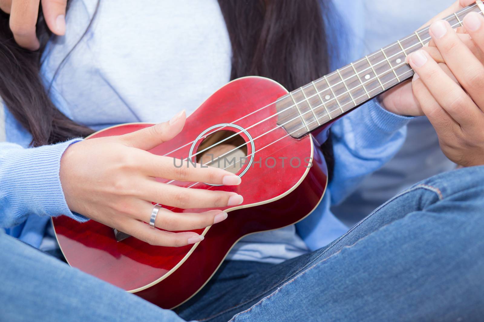 Young Asian couple playing ukulele relaxing with happiness and joyful in bedroom.