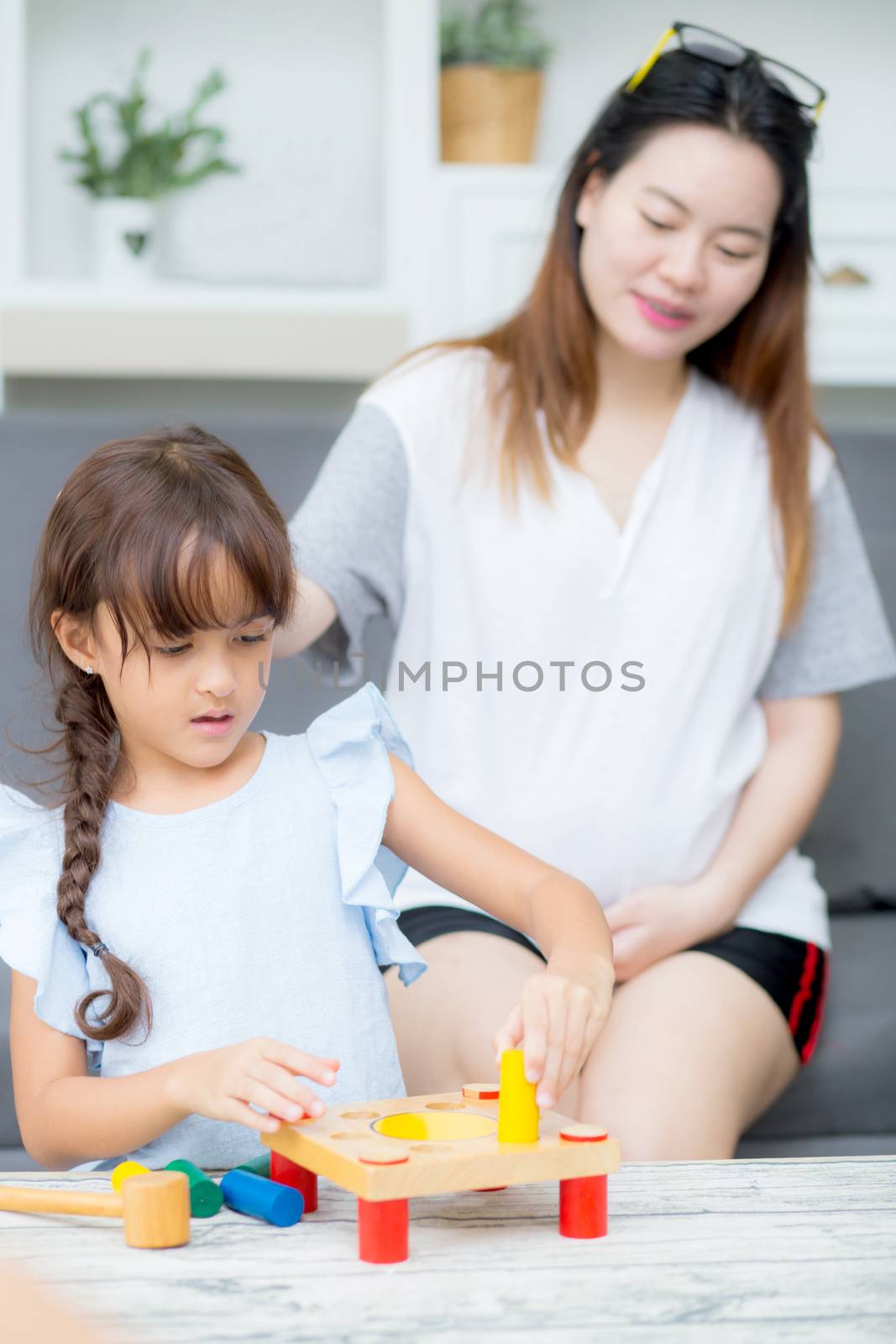 Asian kid girl and mother playing toy block; together with cheer by nnudoo