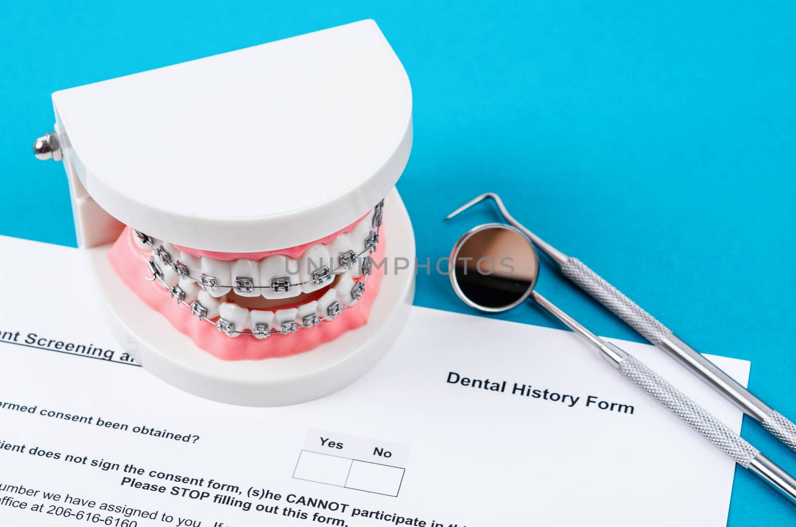 Dental History Form with model tooth and dental instruments. Dental health and teeth care concept.