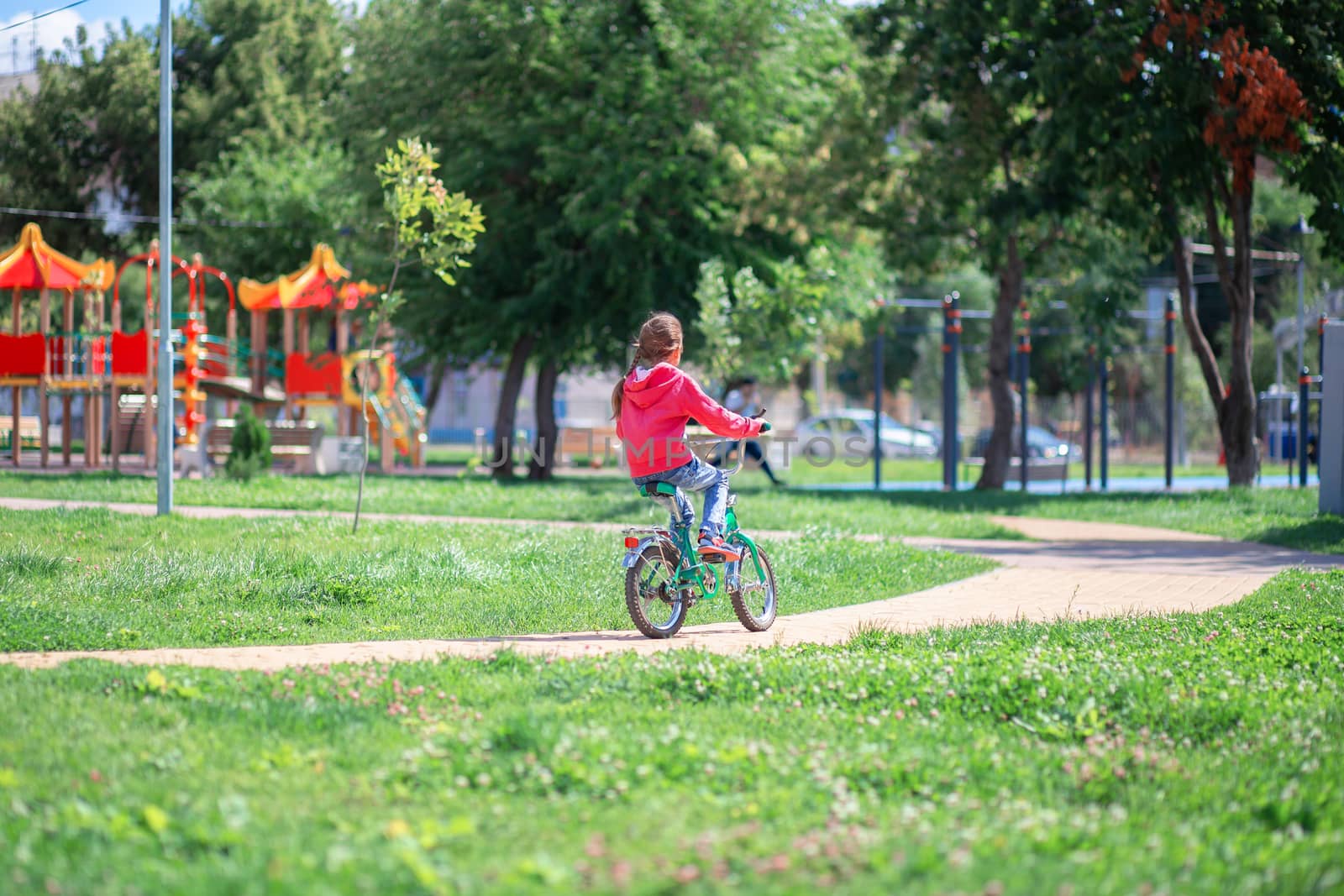 Child rides a child's bike in a summer park