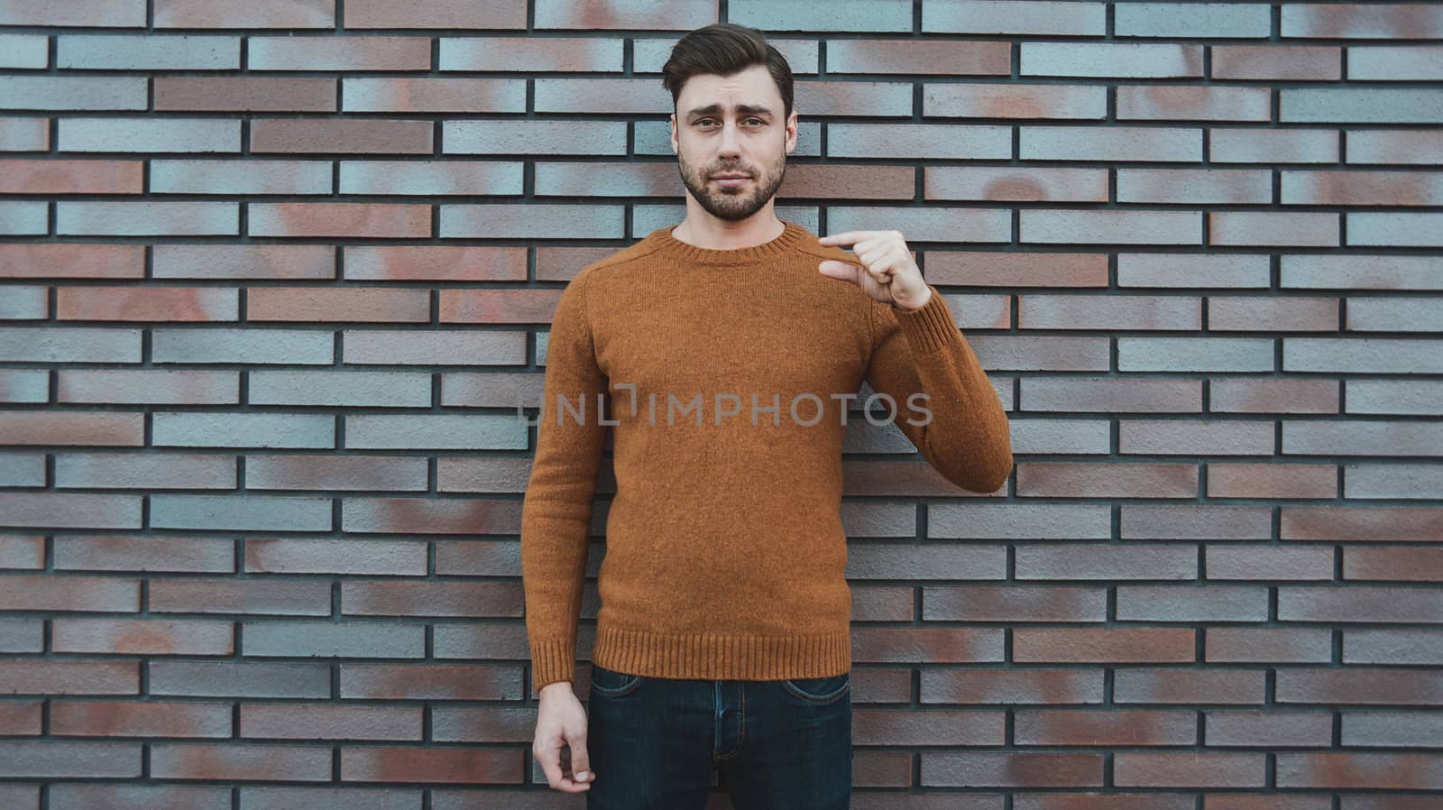 young man hipster holding something small in his hands and smiling.