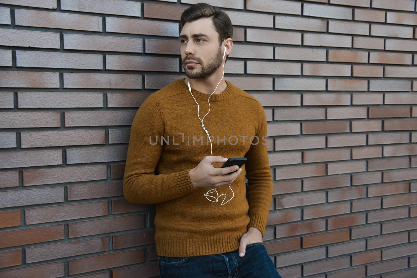 Amazing man holding smartphone in smart casual wear standing.