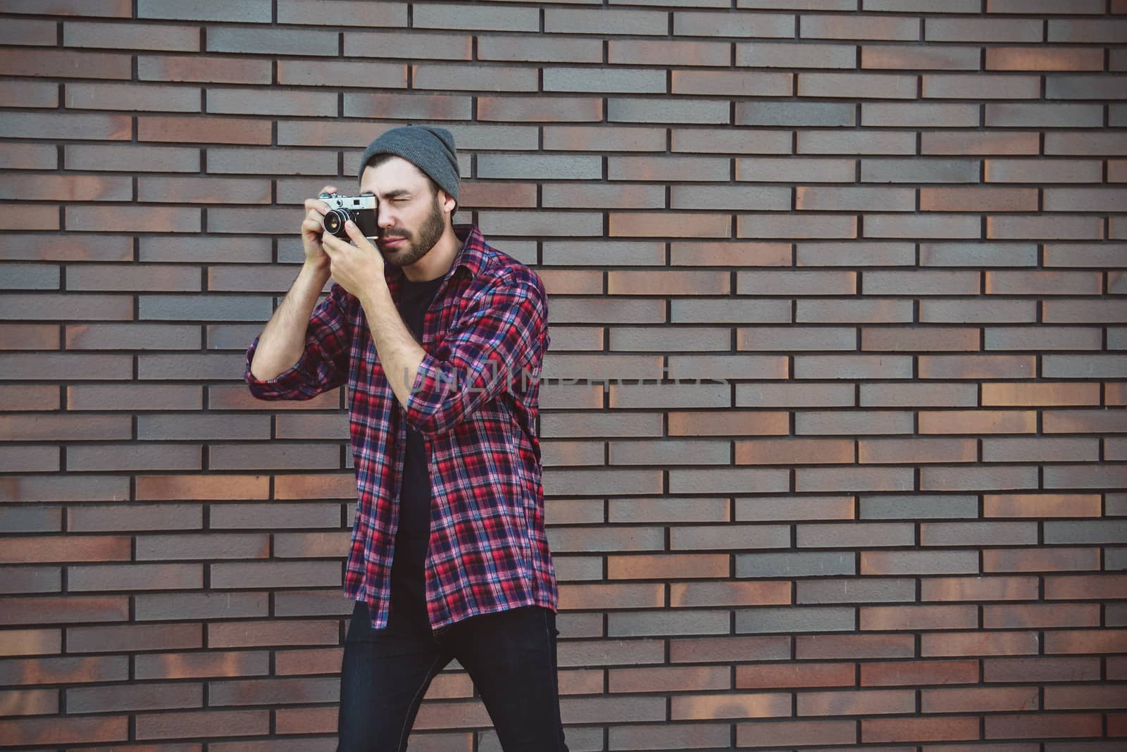 Say cheese, hipster fashion photographer man holding retro camera