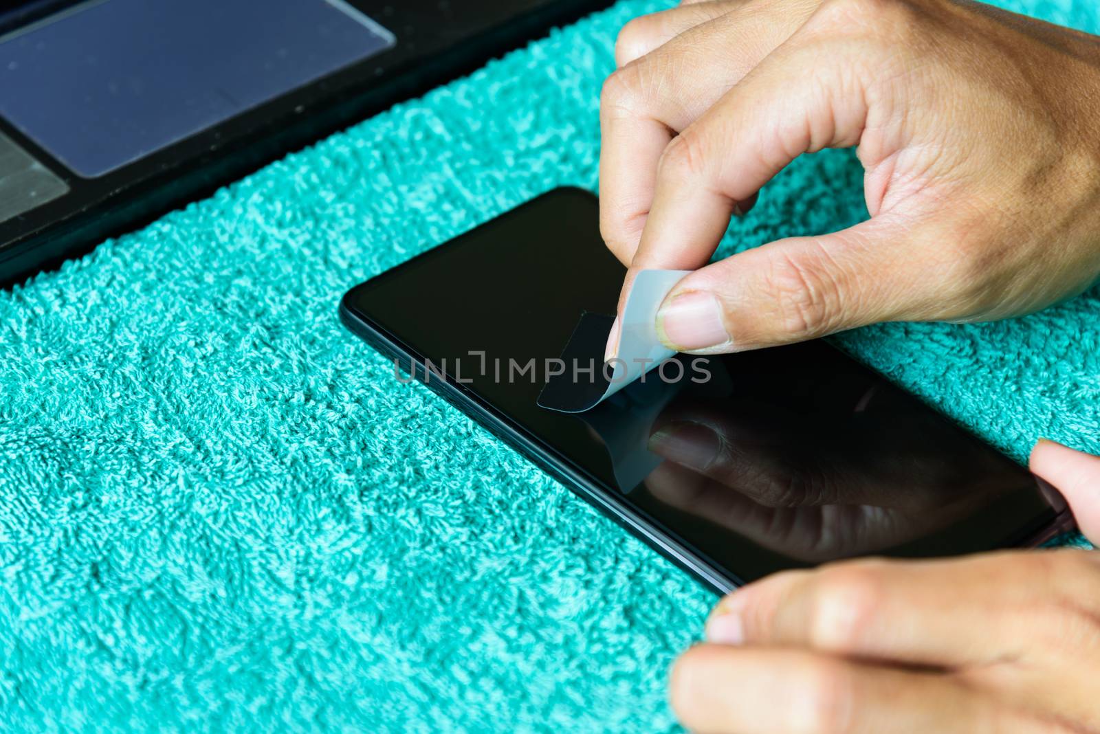 cleaning mobile phone screen by adhesive clear tape. Before apply the smart phone screen protect flim