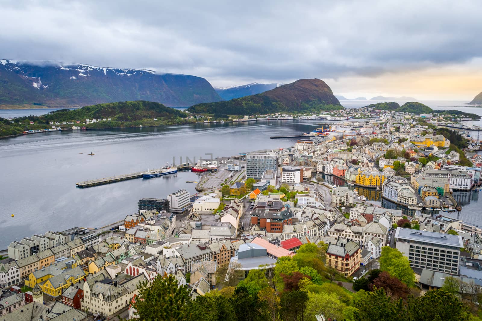 Skyline and cityscape of Alesund, Norway, on a cloudy day. Ocean bay in the background, bright houses and architecture in the foreground. Aerial view. by kb79