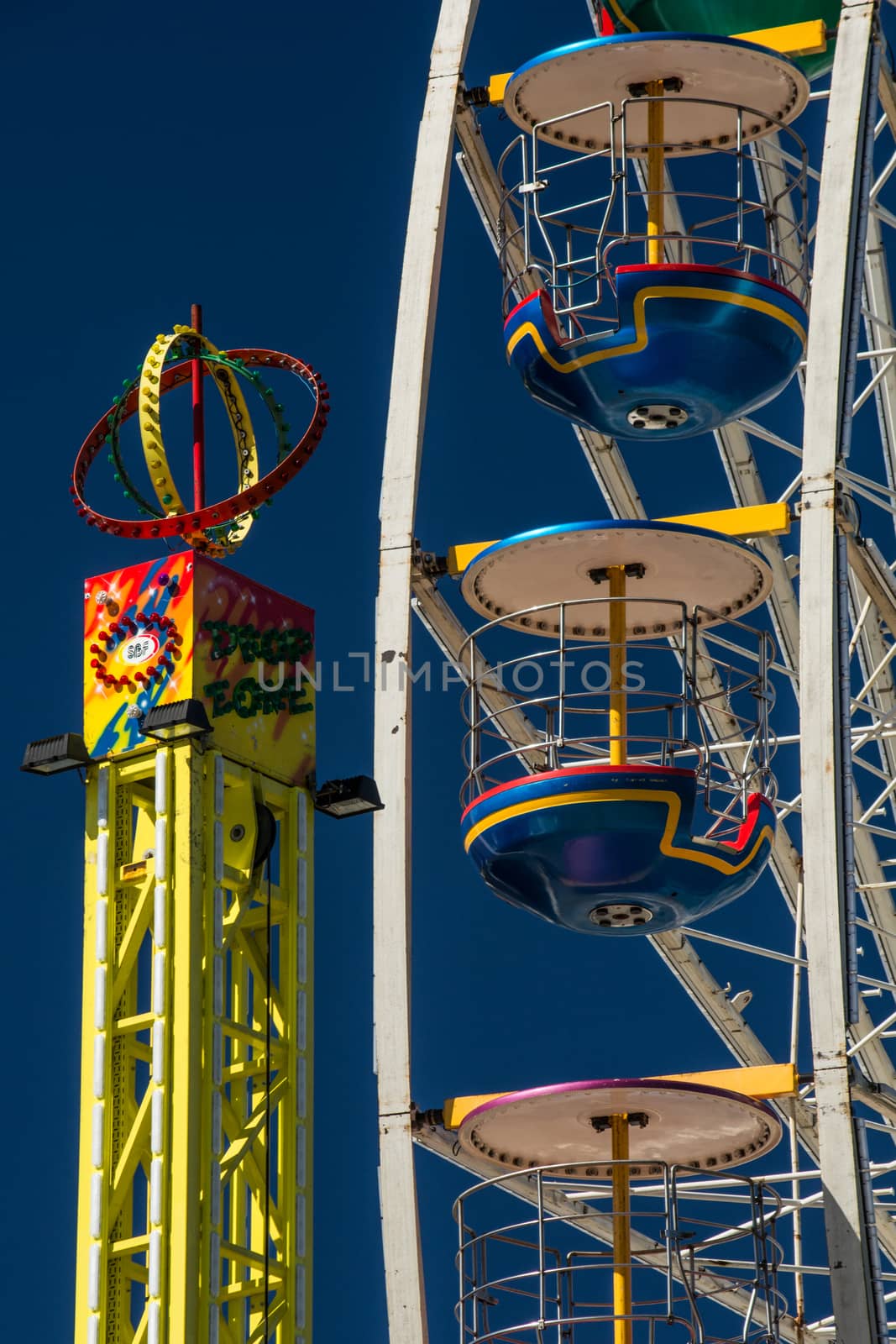 close-up and detail of colorful ferris wheel on blue sky by kb79