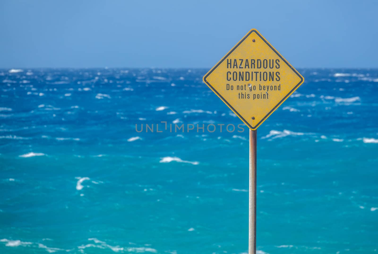 A Sign Beside The Ocean In Hawaii Warning Of Hazardous Conditions