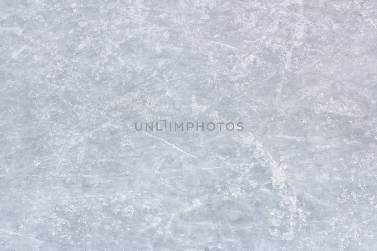 Close up of white ice surface with a traces left by the skates. Ideal for texture and backgrounds.