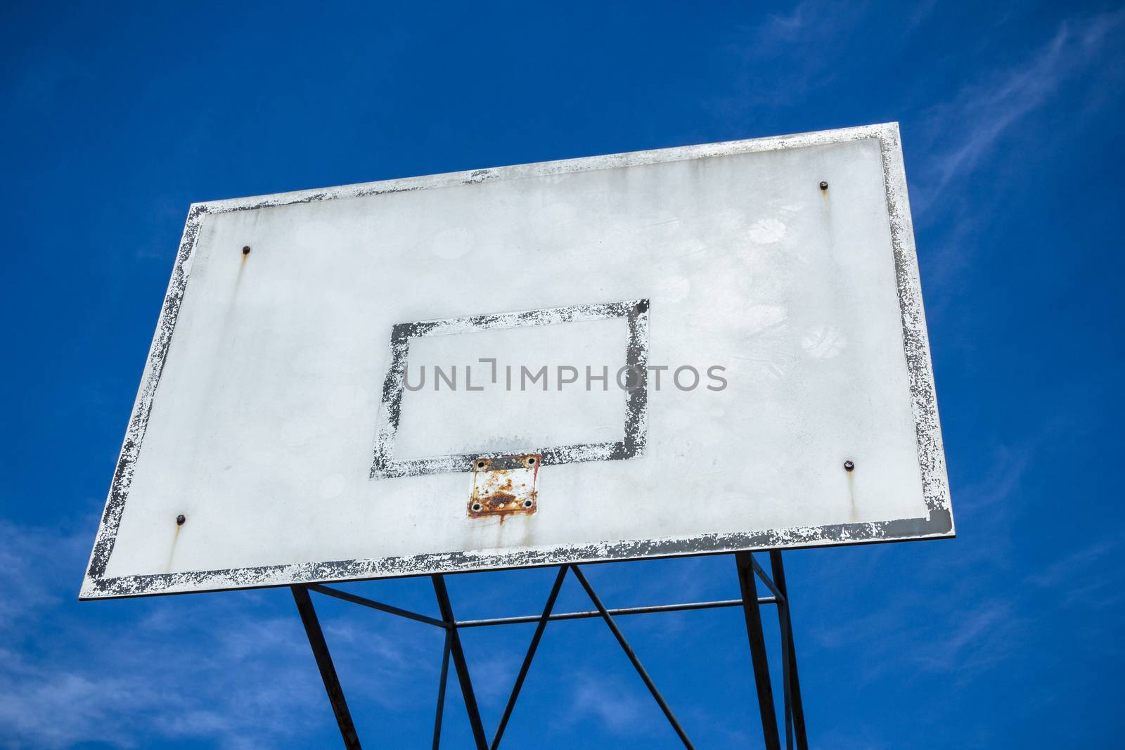 An old basketball hoop consumed by games and matches.