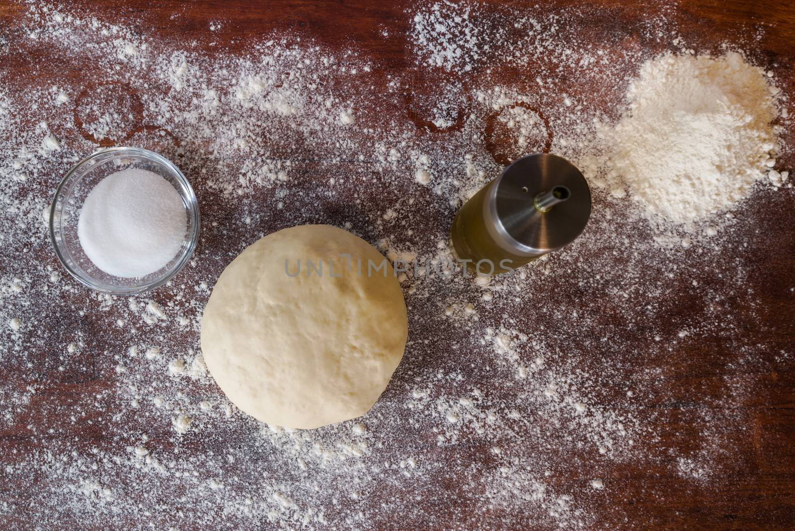 Dough for pizza over a wooden table seen from above