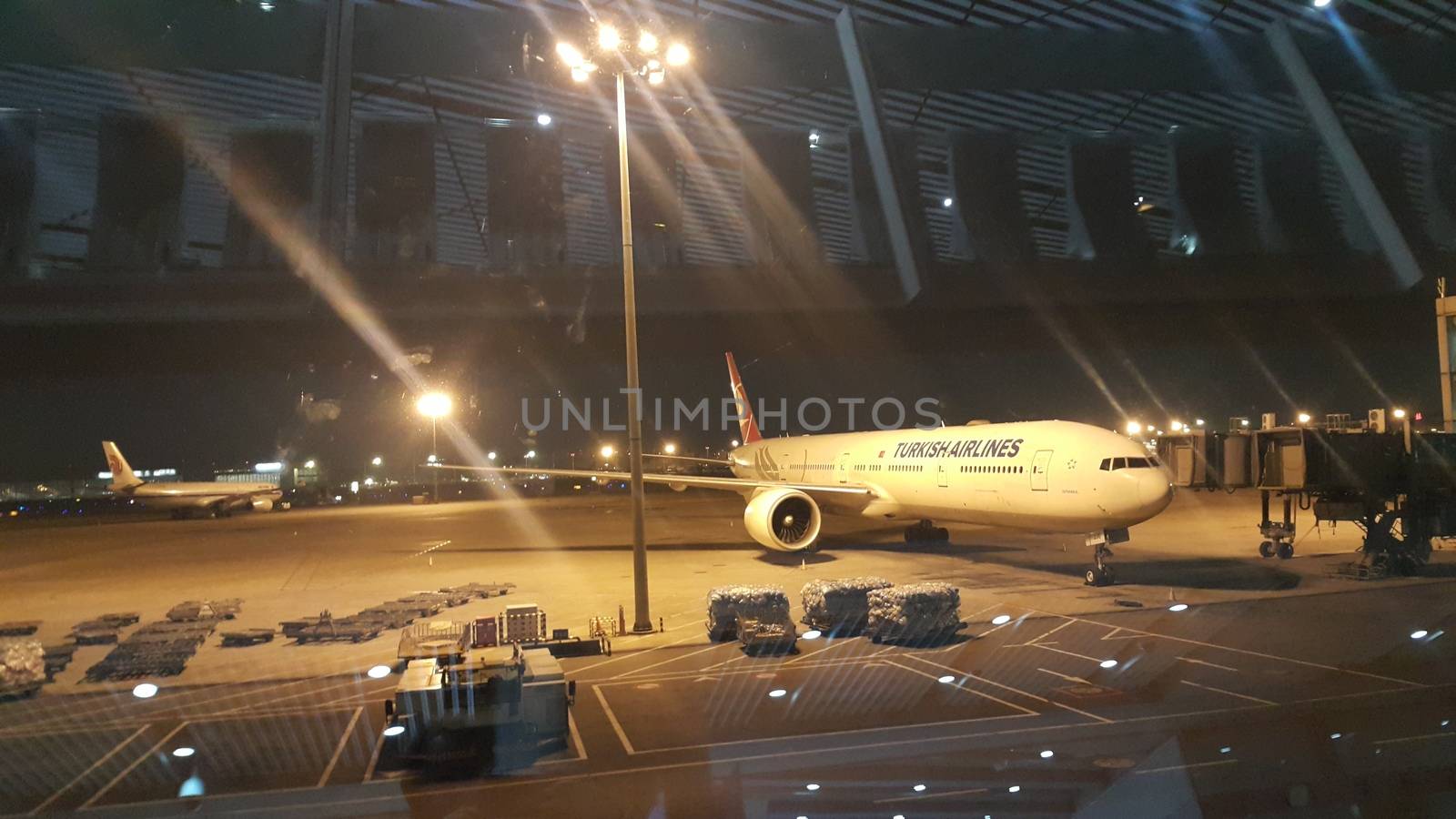 Beijing Airport, china- April 2019: Night view of passenger plane standing in airport on the concrete paved runway terminal for loading, boarding and maintenance before take off for predestined flights.