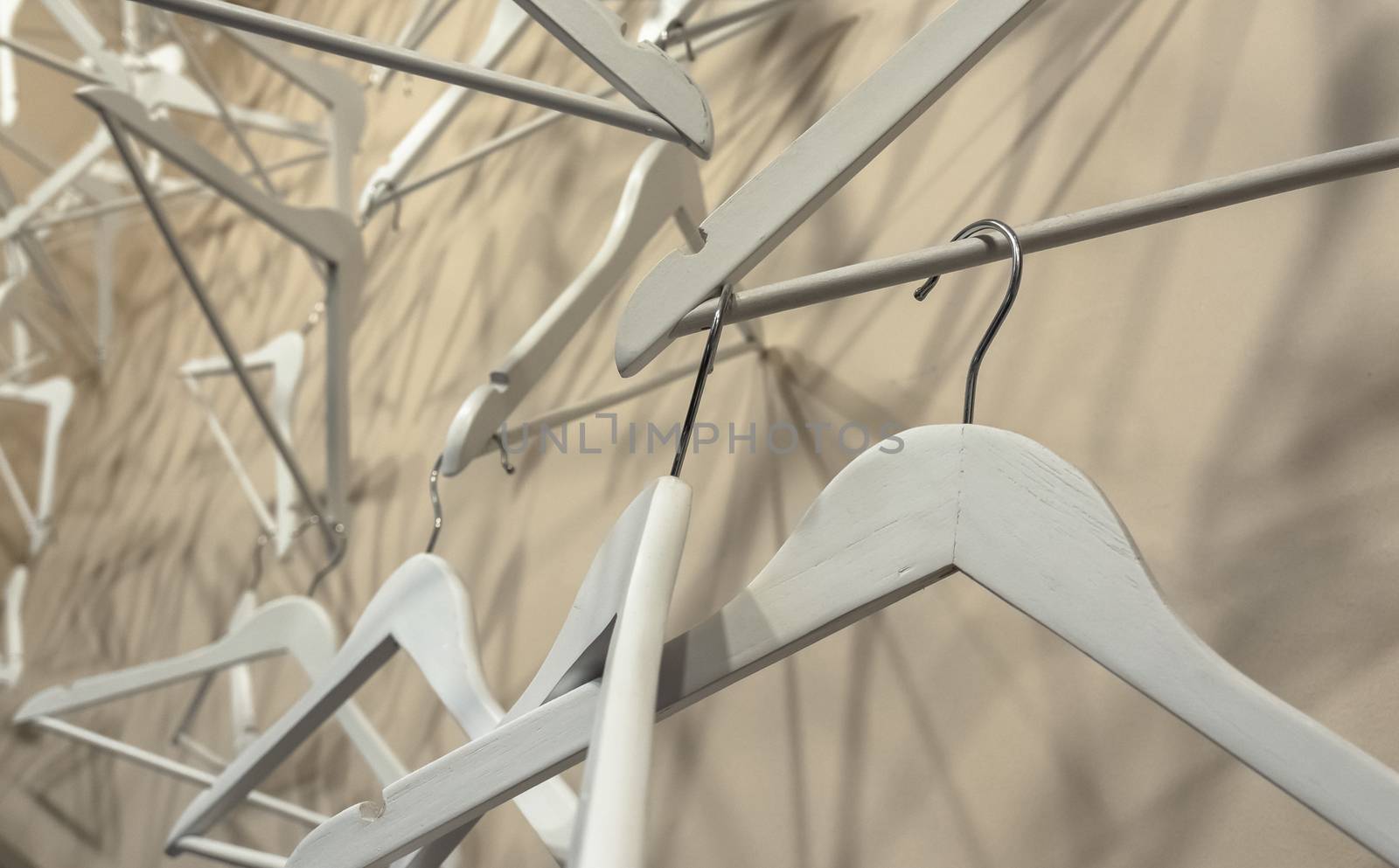 Empty wooden clothes hangers casting deep shadows. Real coat hanger wood pattern. Abstract fashion concept.