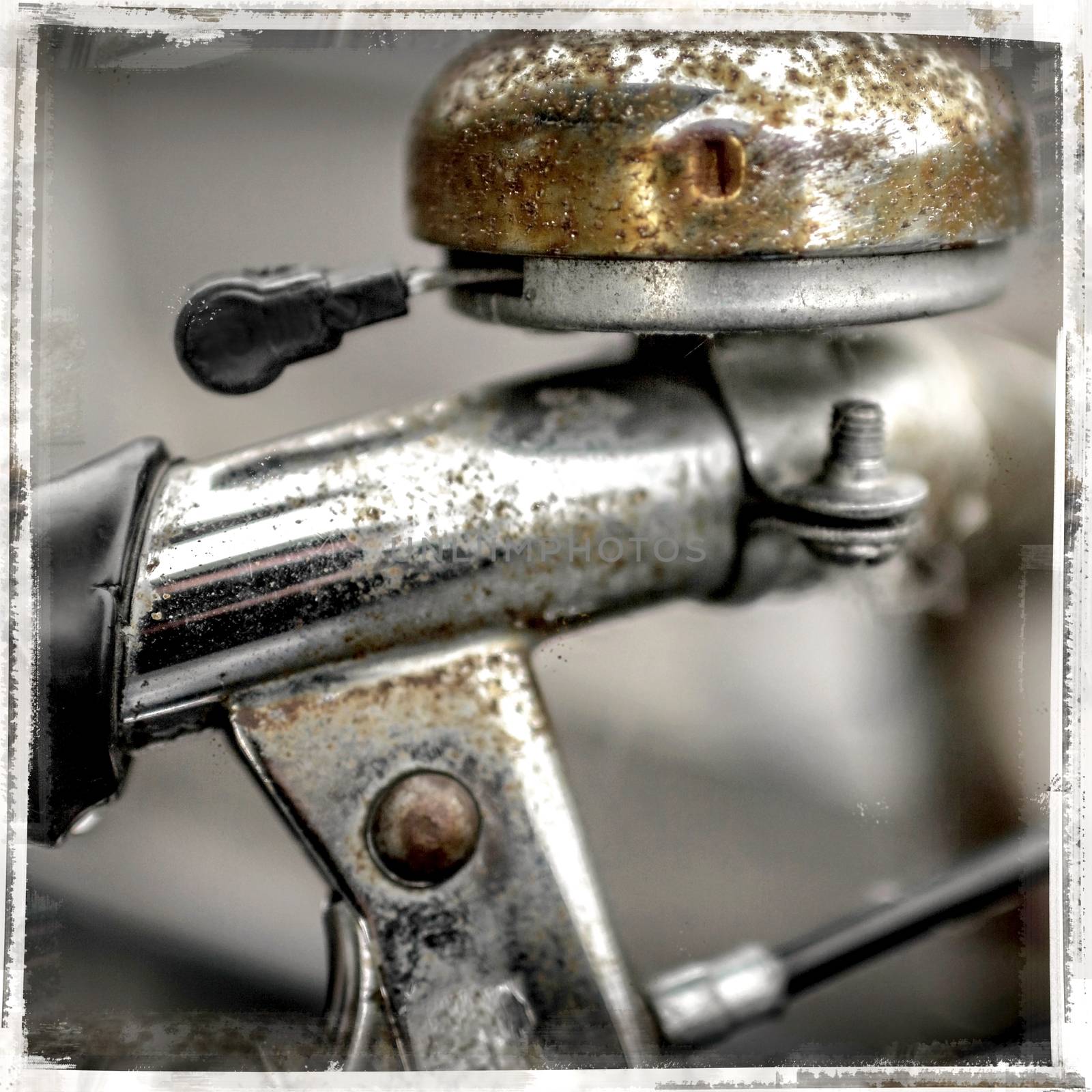 Rusty handlebar and bicycle bell close up. Vintage style frame. Defocused blurry background.