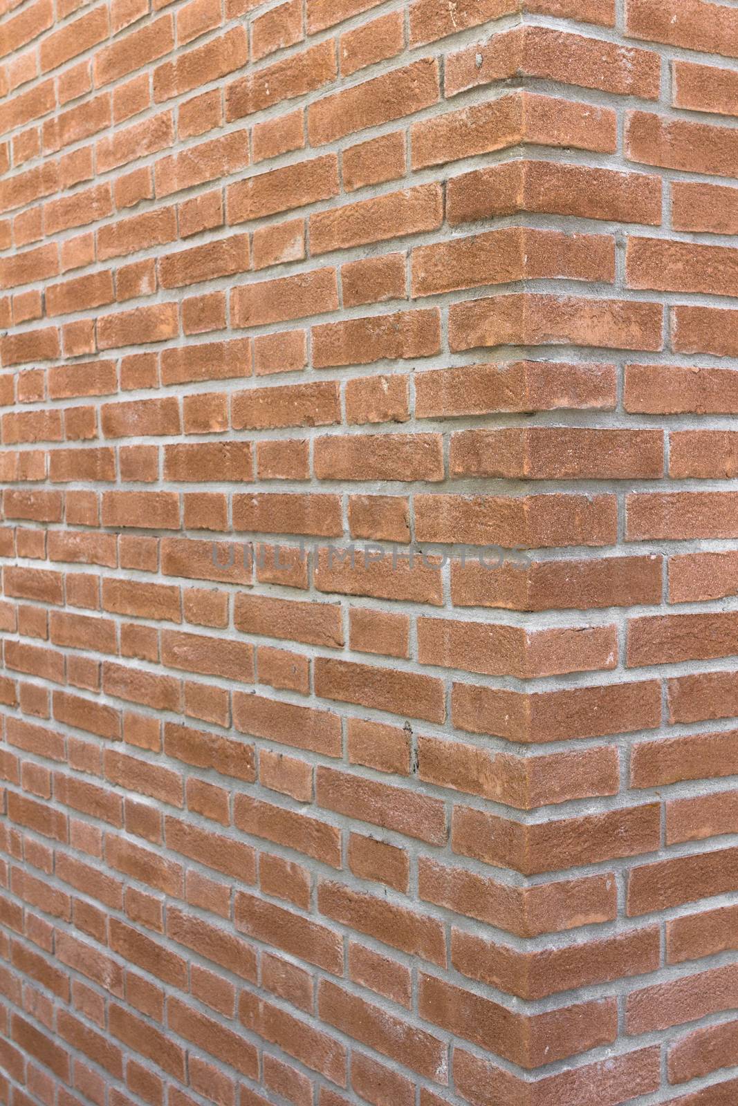 Front view of a wall with bricks arranged in a regular mode.