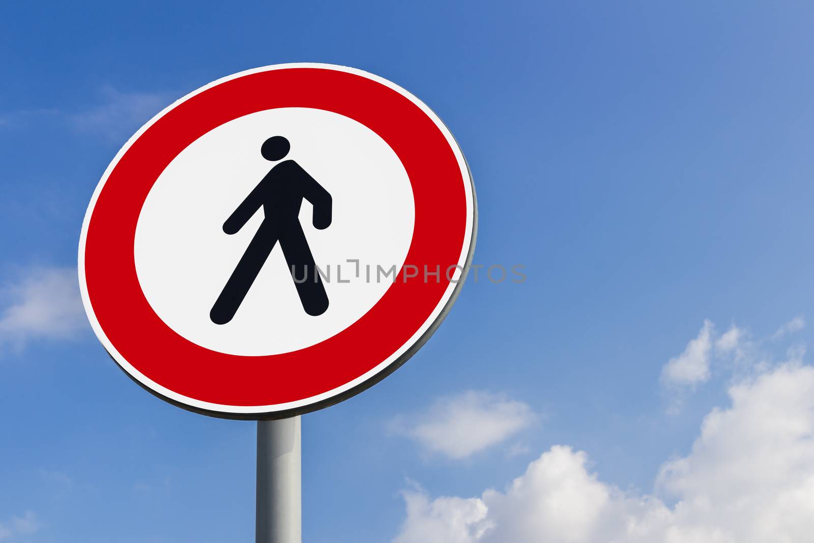 Walking forbidden sign on a blue sky with clouds