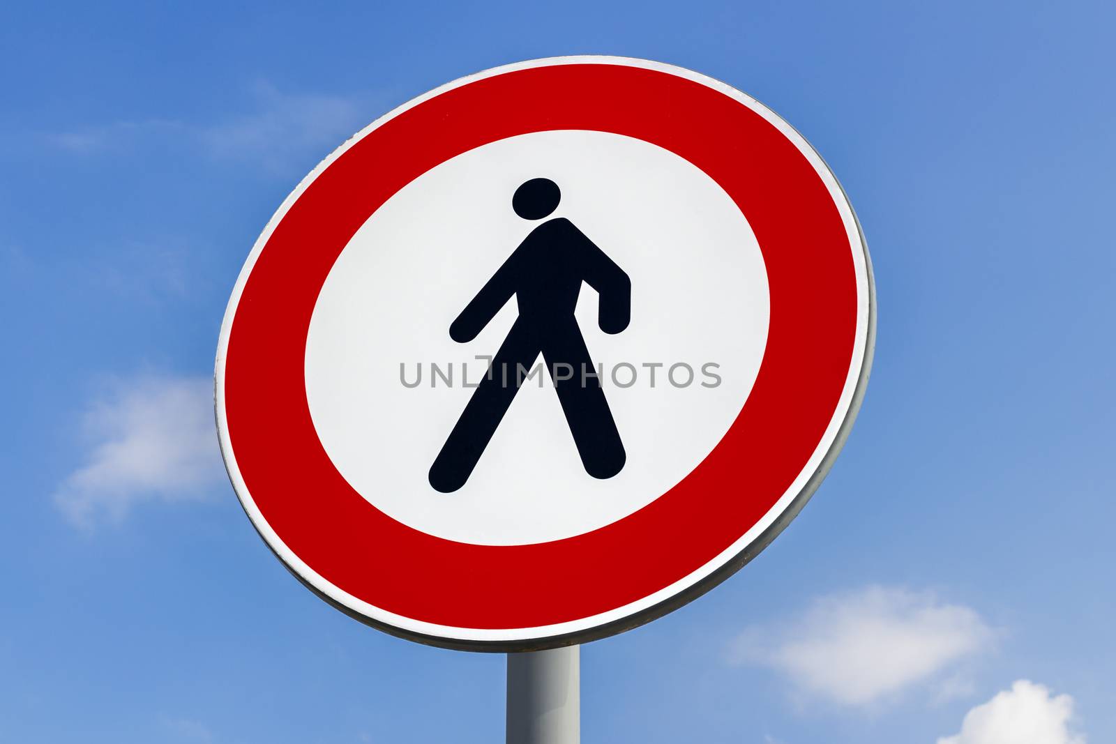 Walking forbidden sign on a blue sky with clouds