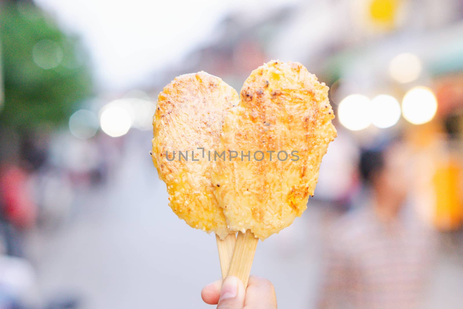 Closeup hand holding Grilled sticky rice with egg on walking str by pt.pongsak@gmail.com