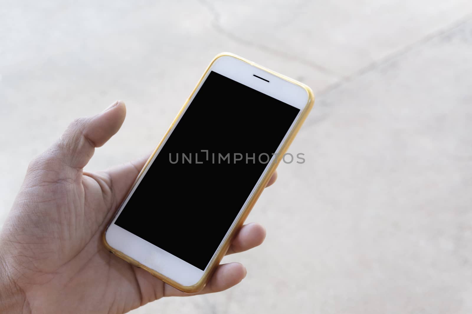 Closeup of men's hands, businessman holding a smartphone with a clean white screen and a black screen with a mockup design, stay outdoors to play social media or check stock, along with the vivid visual style on the street background.