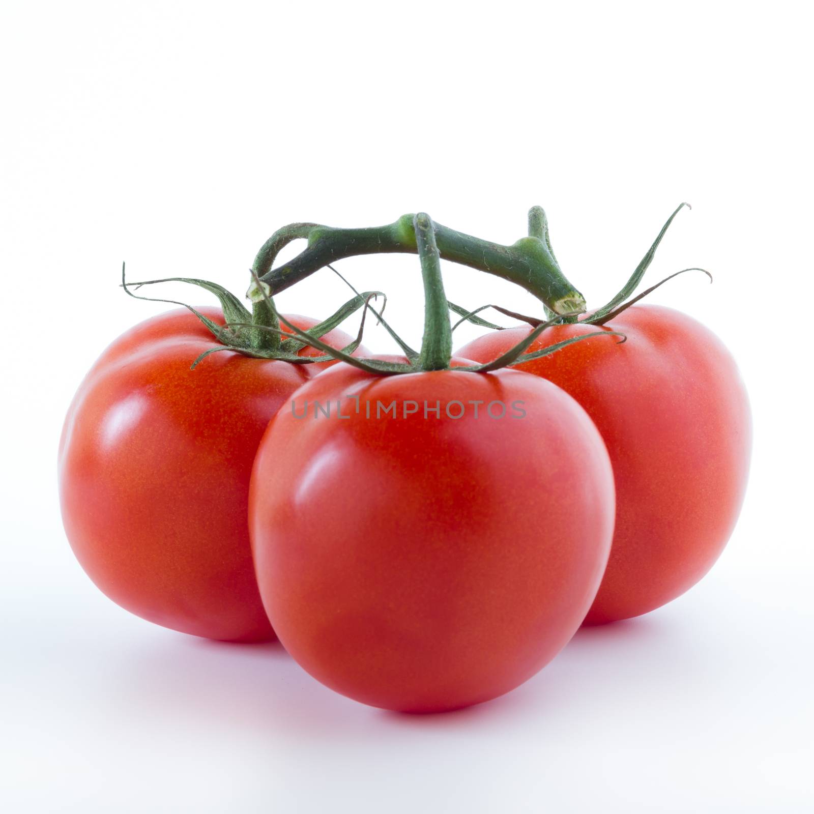 Three ripe tomatoes, isolated on white background.