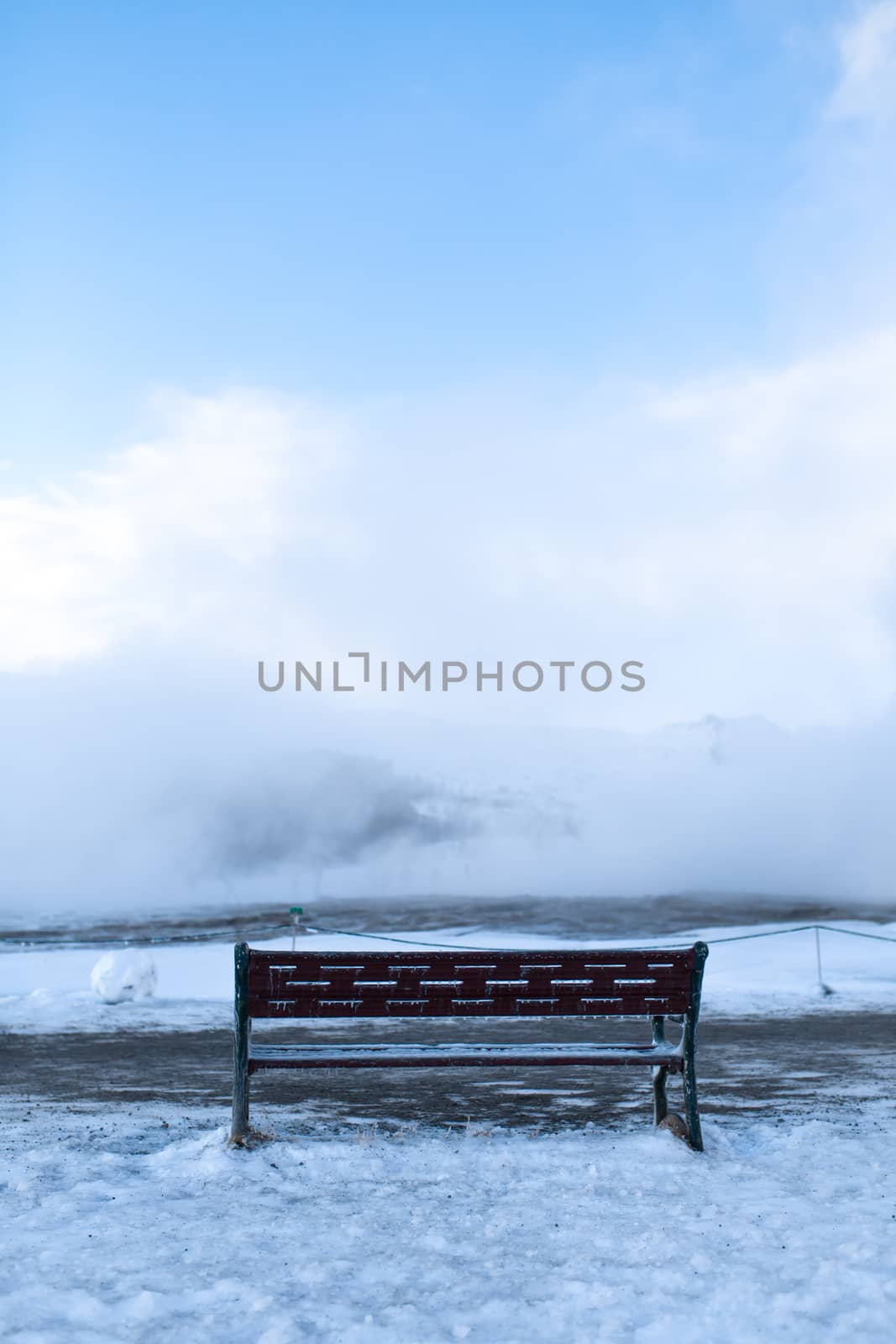 Bench for rest overlooking a cloud of steam in winter.