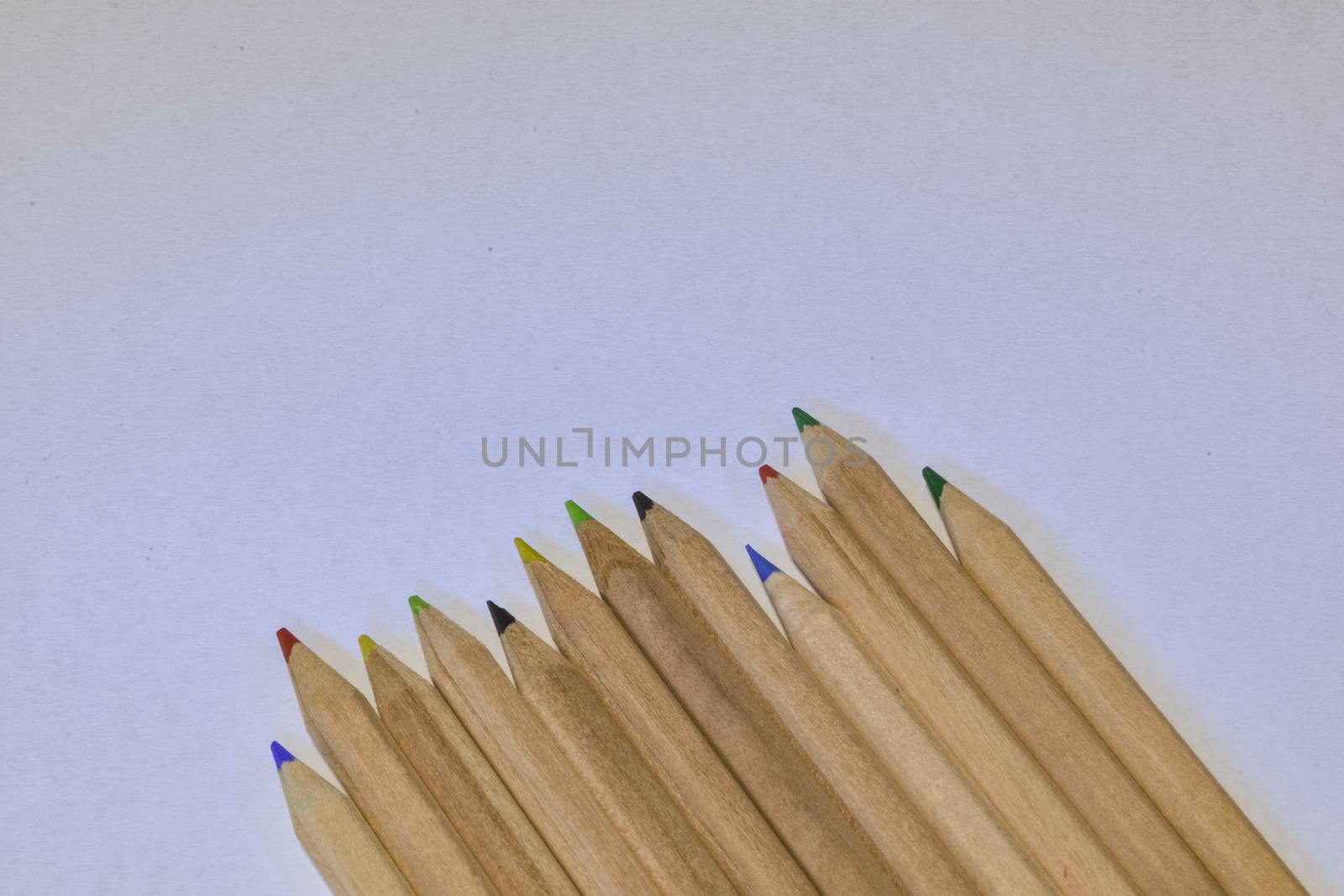 colored crayons lined up on a white pape , horizontal image by brambillasimone