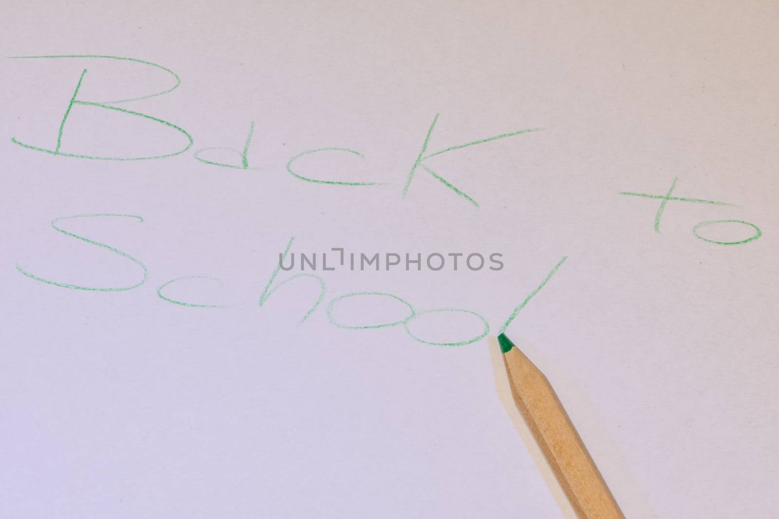 Written "back to school" made with a colored pencil on white pap by brambillasimone