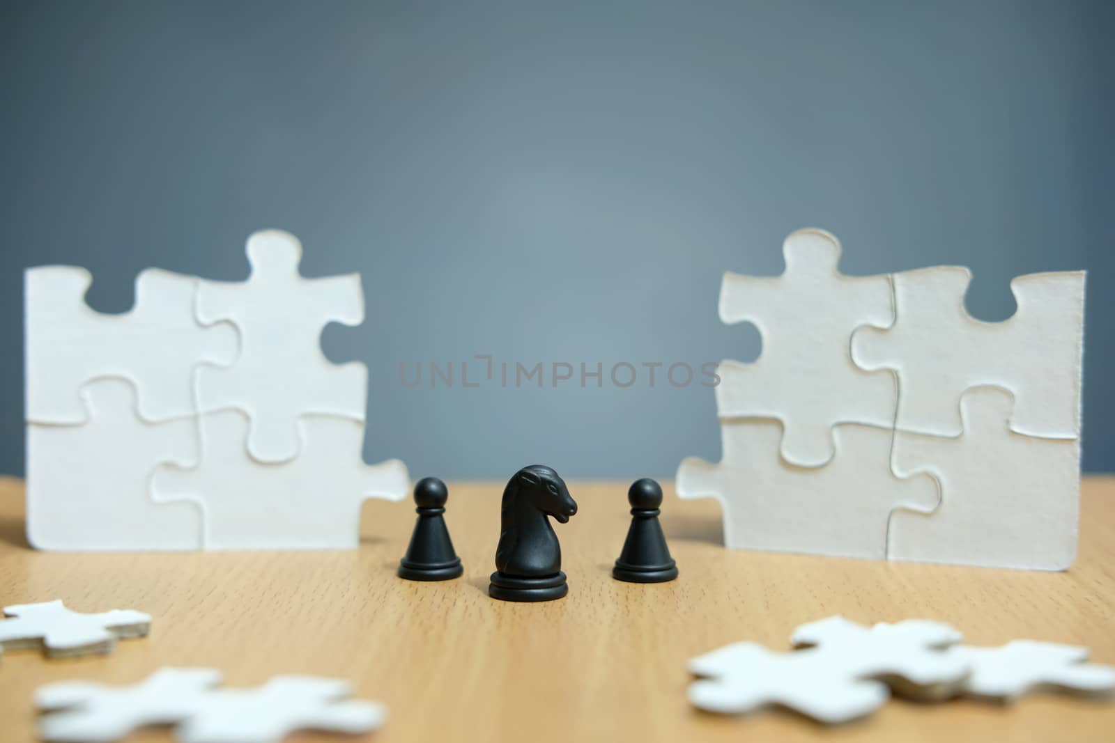 Business strategy conceptual photo - horse knight and chess pawn standing in the center of jigsaw puzzle piece that are arranged