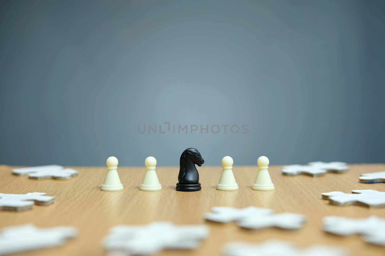 Conceptual photo of business strategy - a line of horse chess pieces in the middle of an army and jigsaw puzzles