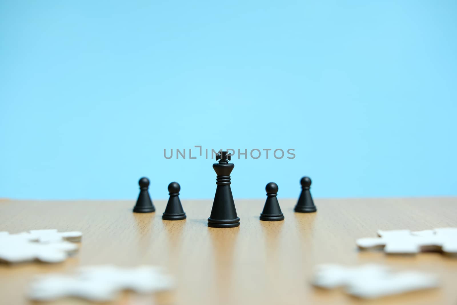 Business strategy conceptual photo - king and chess pawn in line, standing in front of jigsaw puzzle